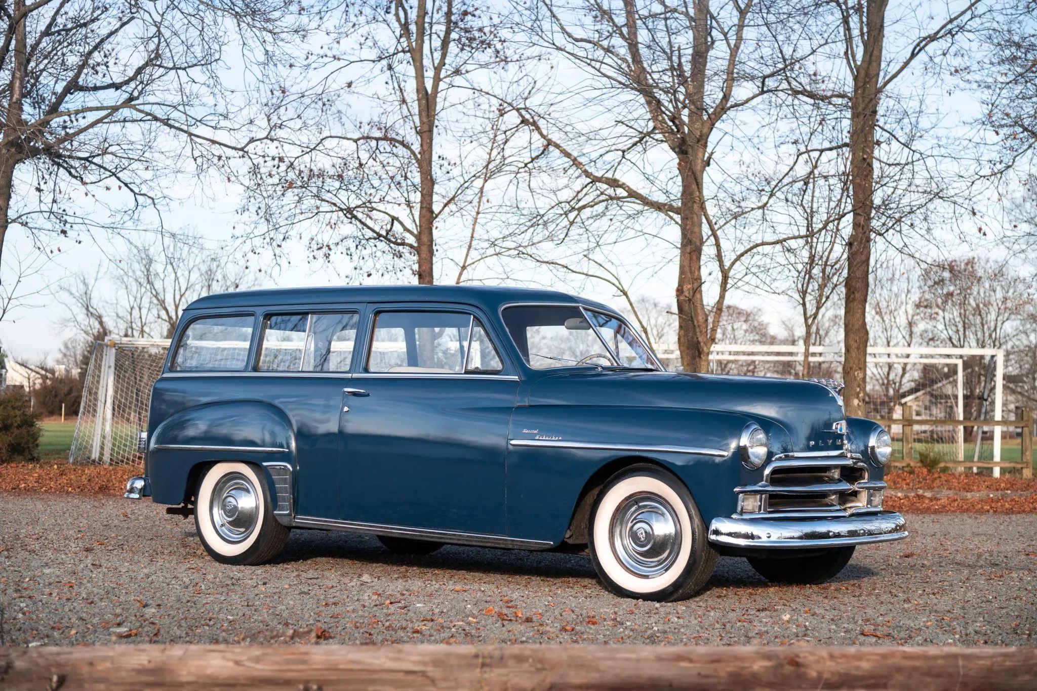 1950 Plymouth Suburban Station Wagon: No Wood, All Rust 8 Picture of passenger side of 1950 Plymouth Suburban in an autumnal setting