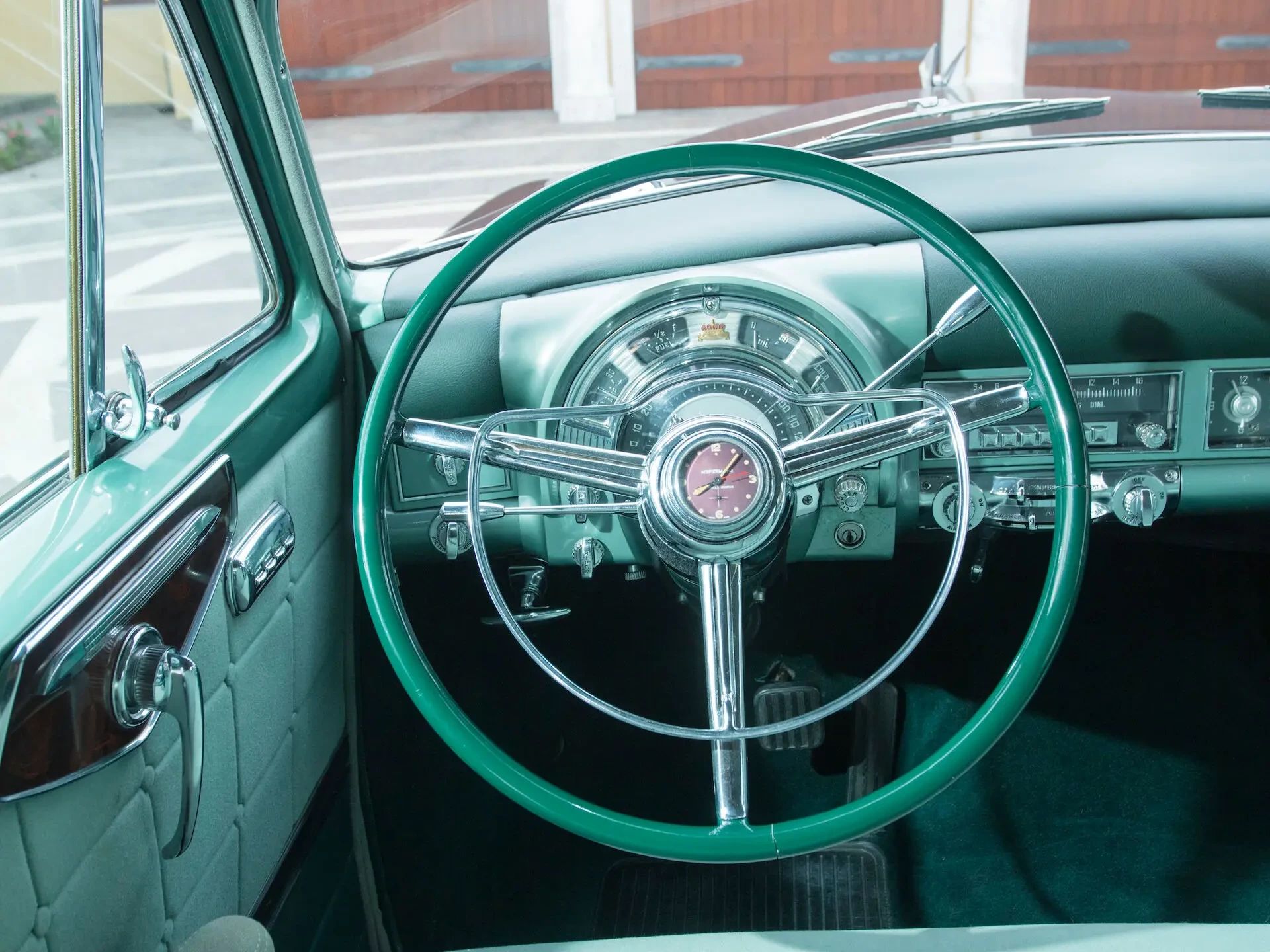 Steering wheel and instrument panel of a 1953 Chrysler Custom Imperial with green interior