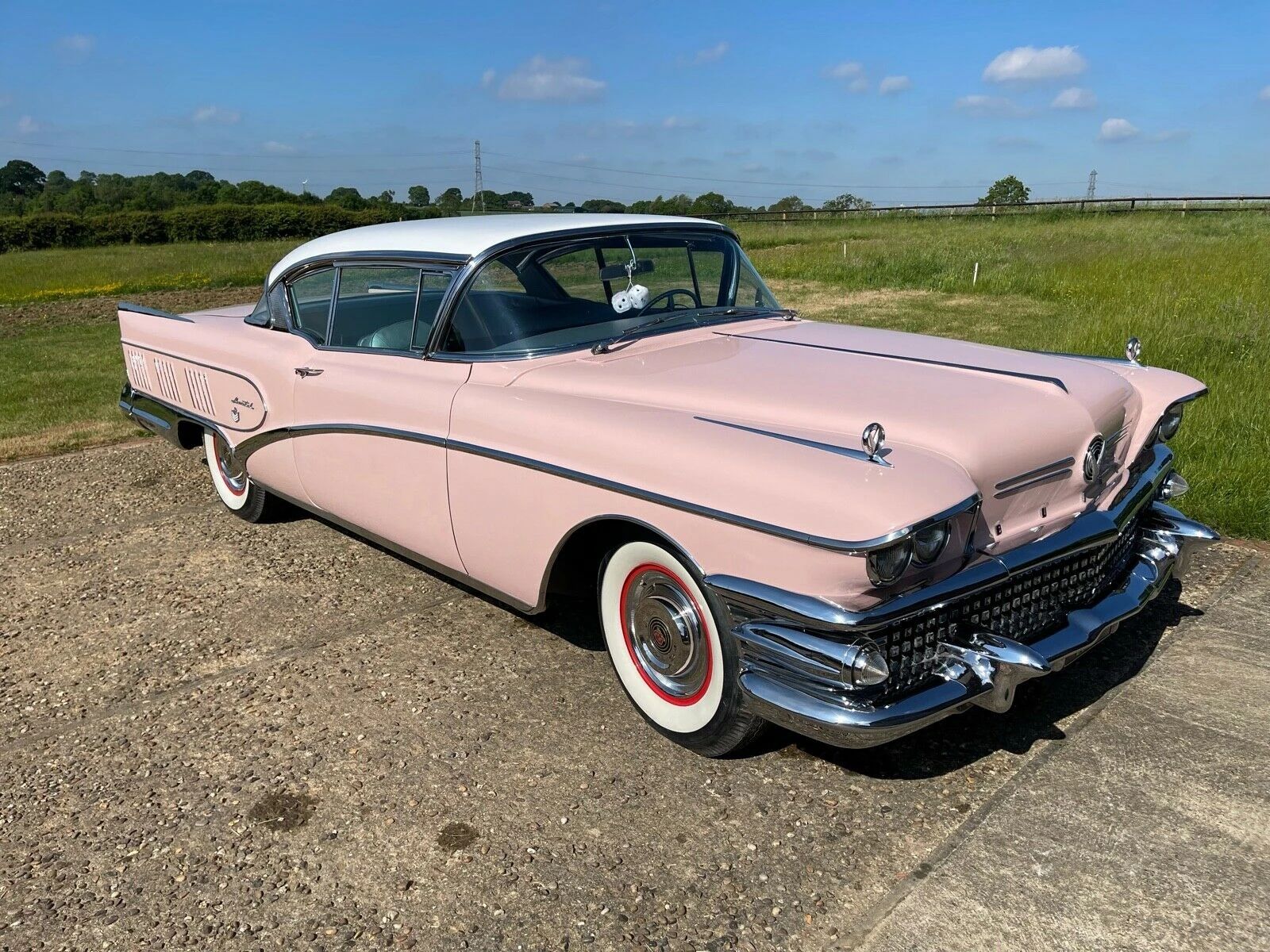 Right front 3q view of a pink 1958 Buick Limited two-door hardtop with a white roof