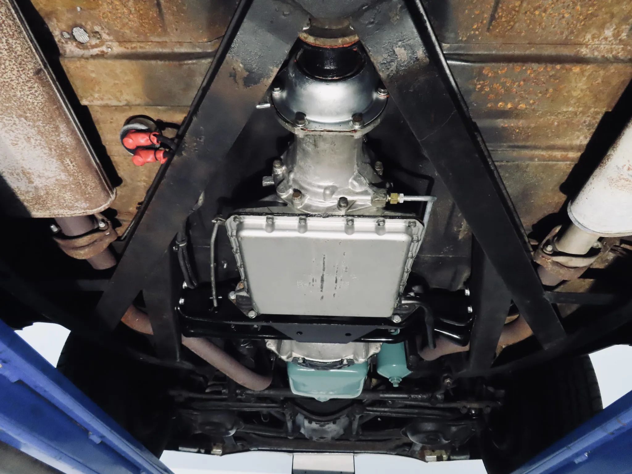 Underside of a 1958 Buick Limited, raised on a hoist to show its transmission and sump
