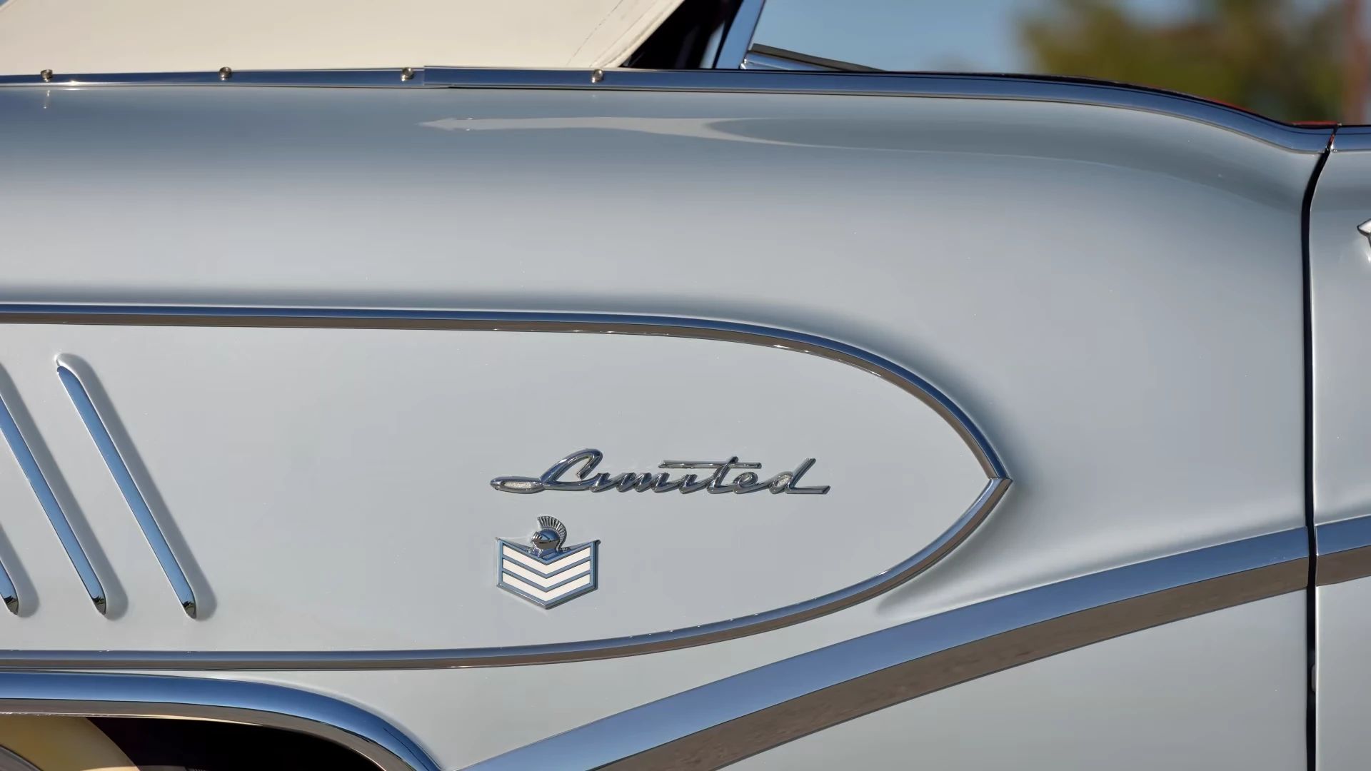 Closeup photo of the Limited badge on the rear fender of a silver 1958 Buick Limited