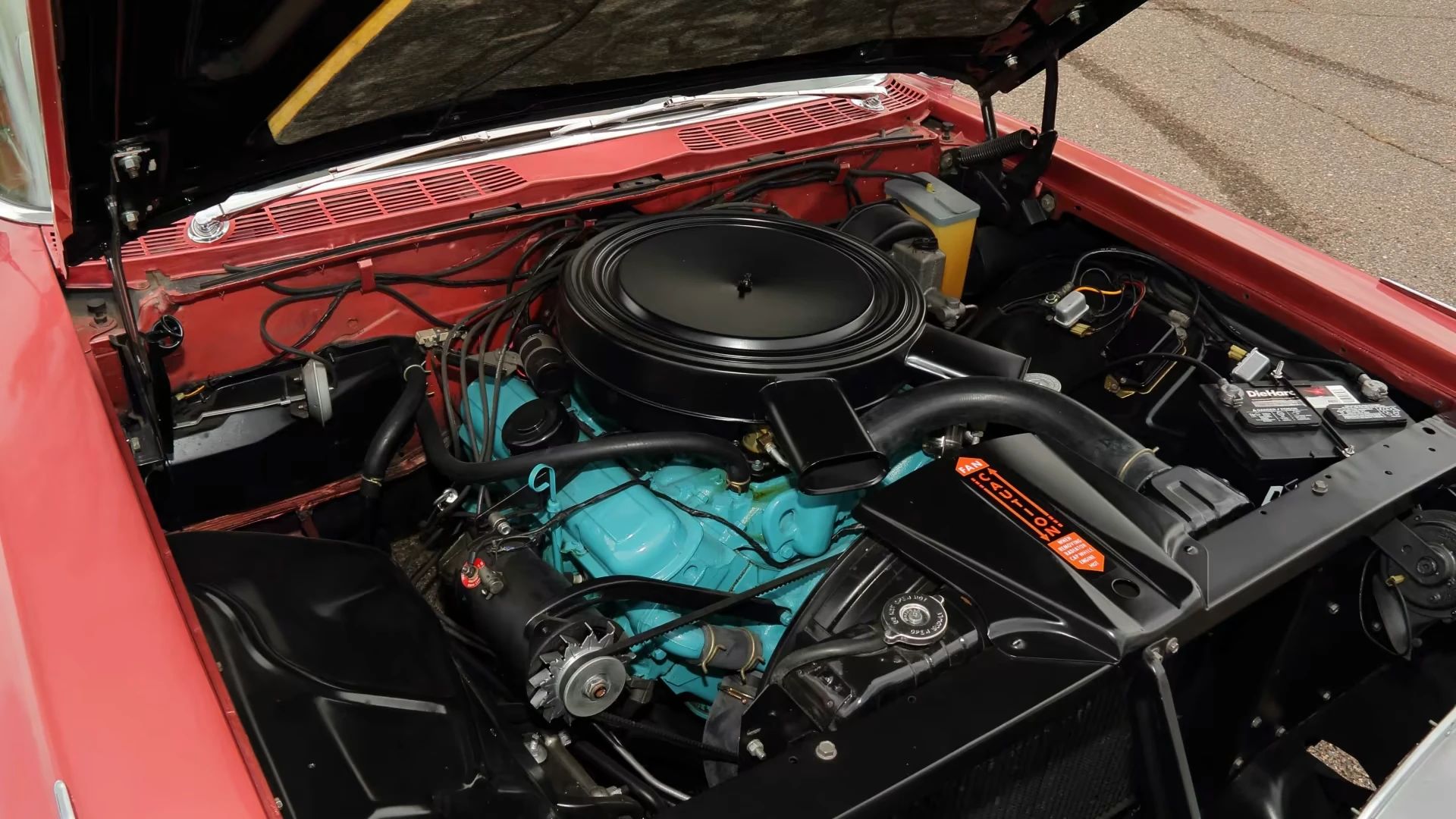 Blue-painted Pontiac 389 Tri-Power engine under the hood of a red 1959 Pontiac Bonneville