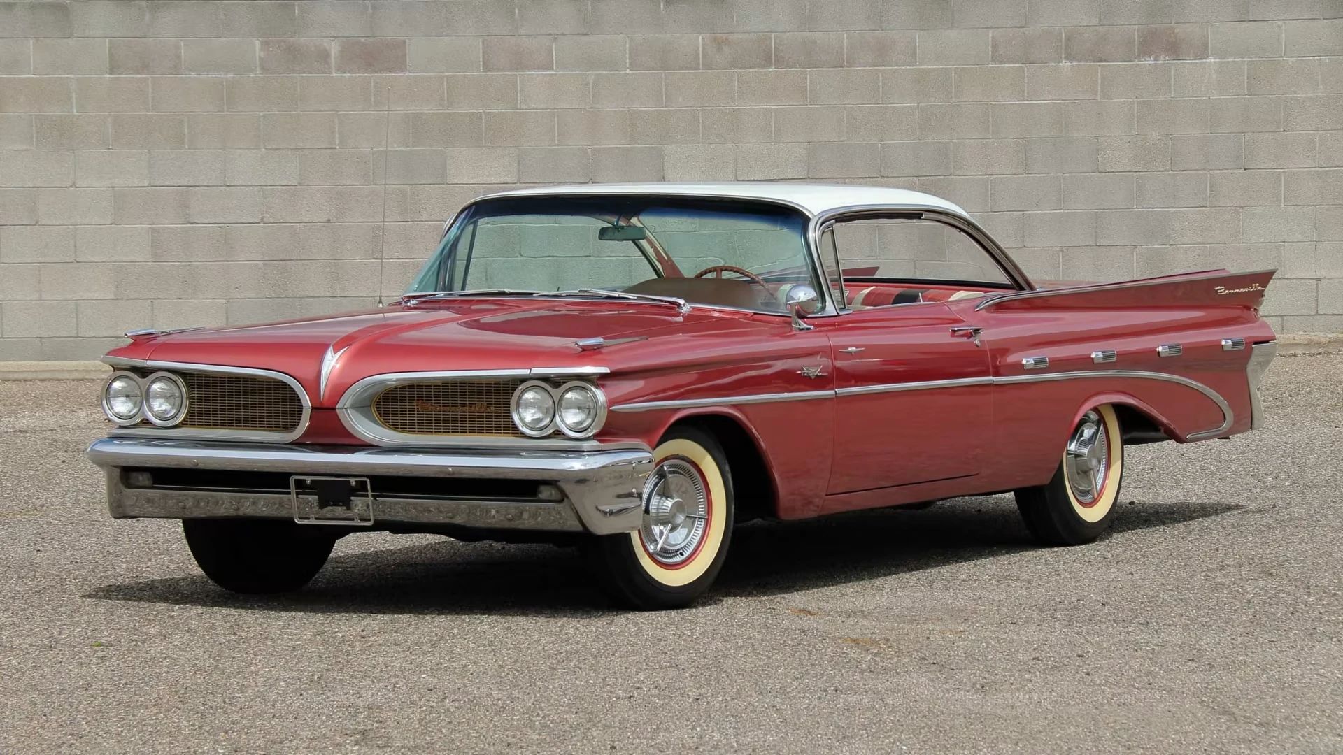 Left front 3q view of a red 1959 Pontiac Bonneville "bubbletop" two-door hardtop with a white roof