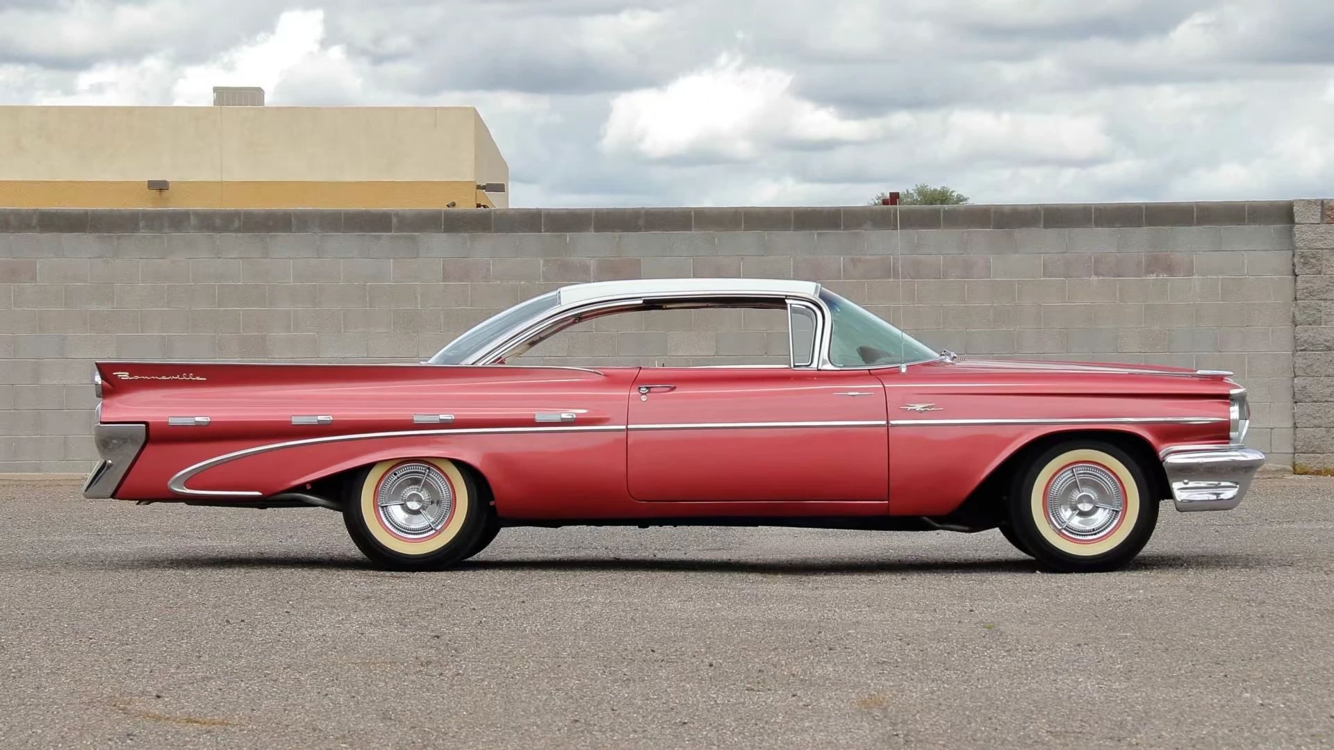 Right side view of a red 1959 Pontiac Bonneville "bubbletop" two-door hardtop with a white roof