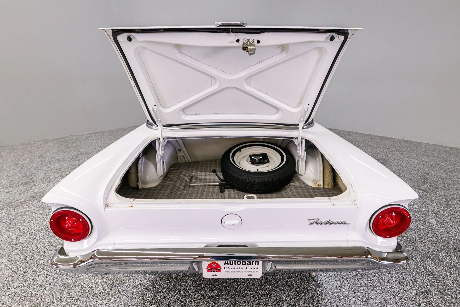 Rear view of a white 1960 Ford Falcon with its trunk open