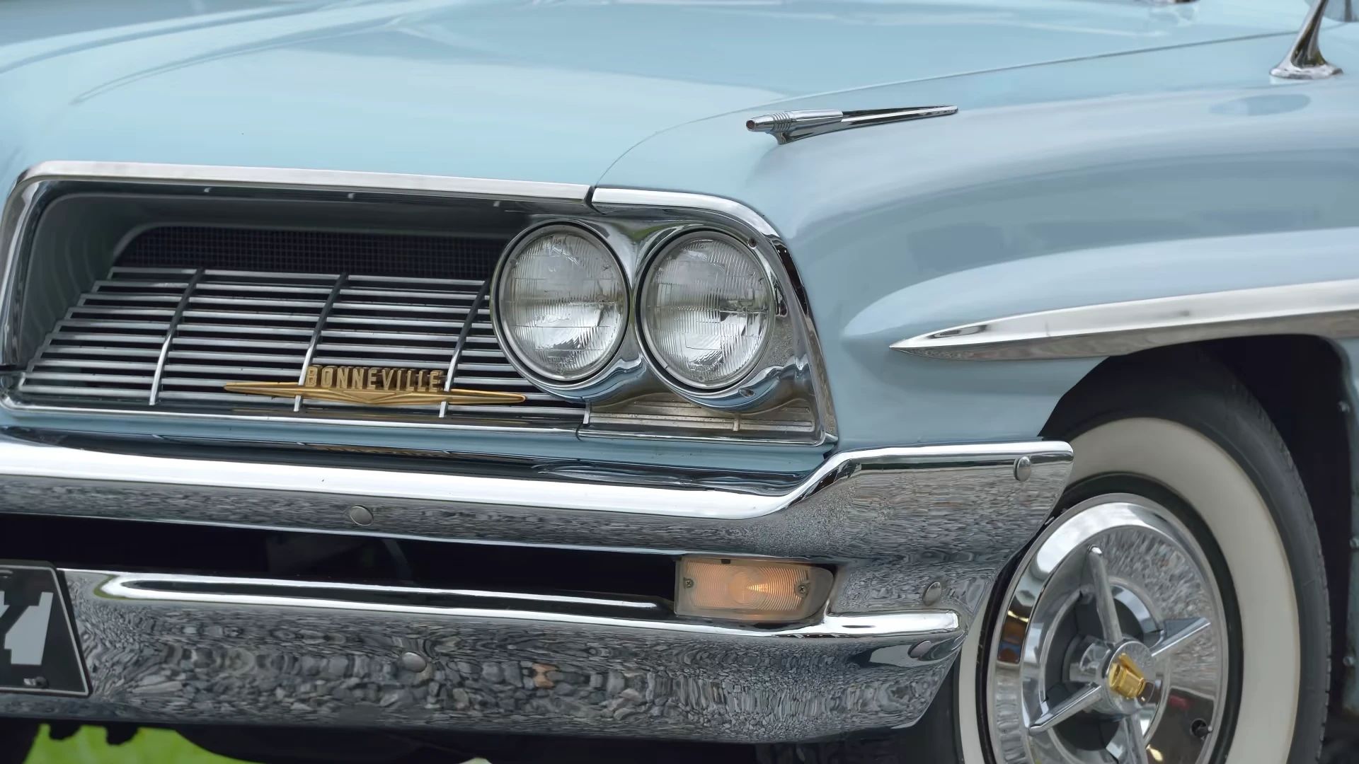 Headlights and front bumper of a light blue 1961 Pontiac Bonneville