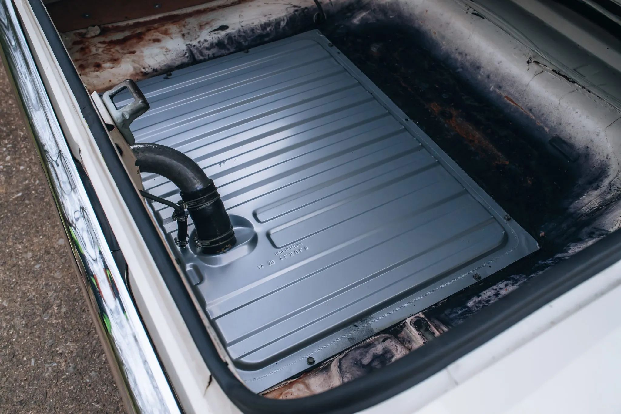 Fuel tank in the trunk of a white 1965 Ford Falcon sedan