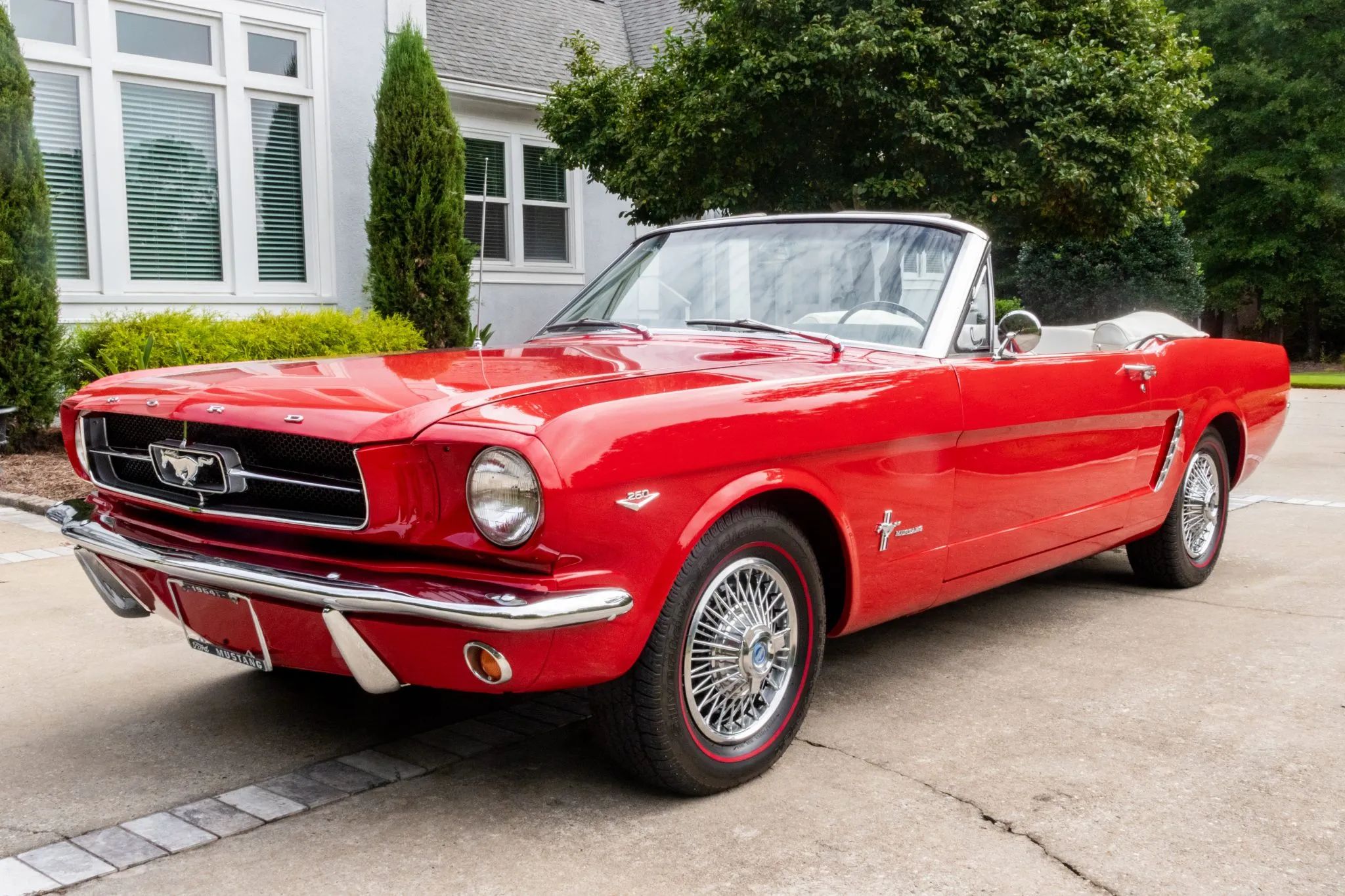 Left front 3q view of a red 1964 Ford Mustang convertible with the top down