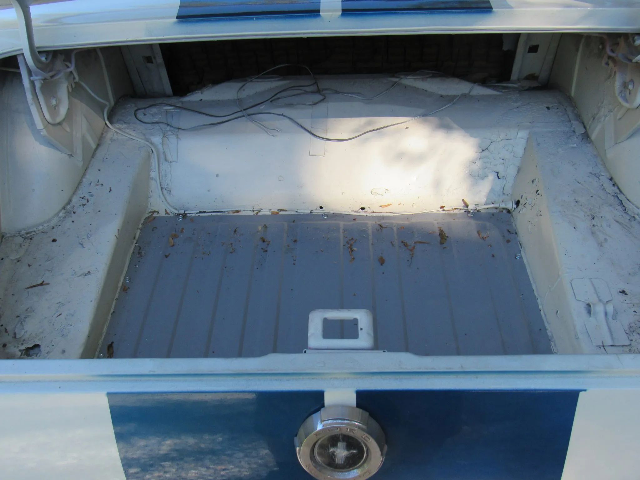 Fuel tank in the bottom of the trunk of a white 1965 Ford Mustang hardtop