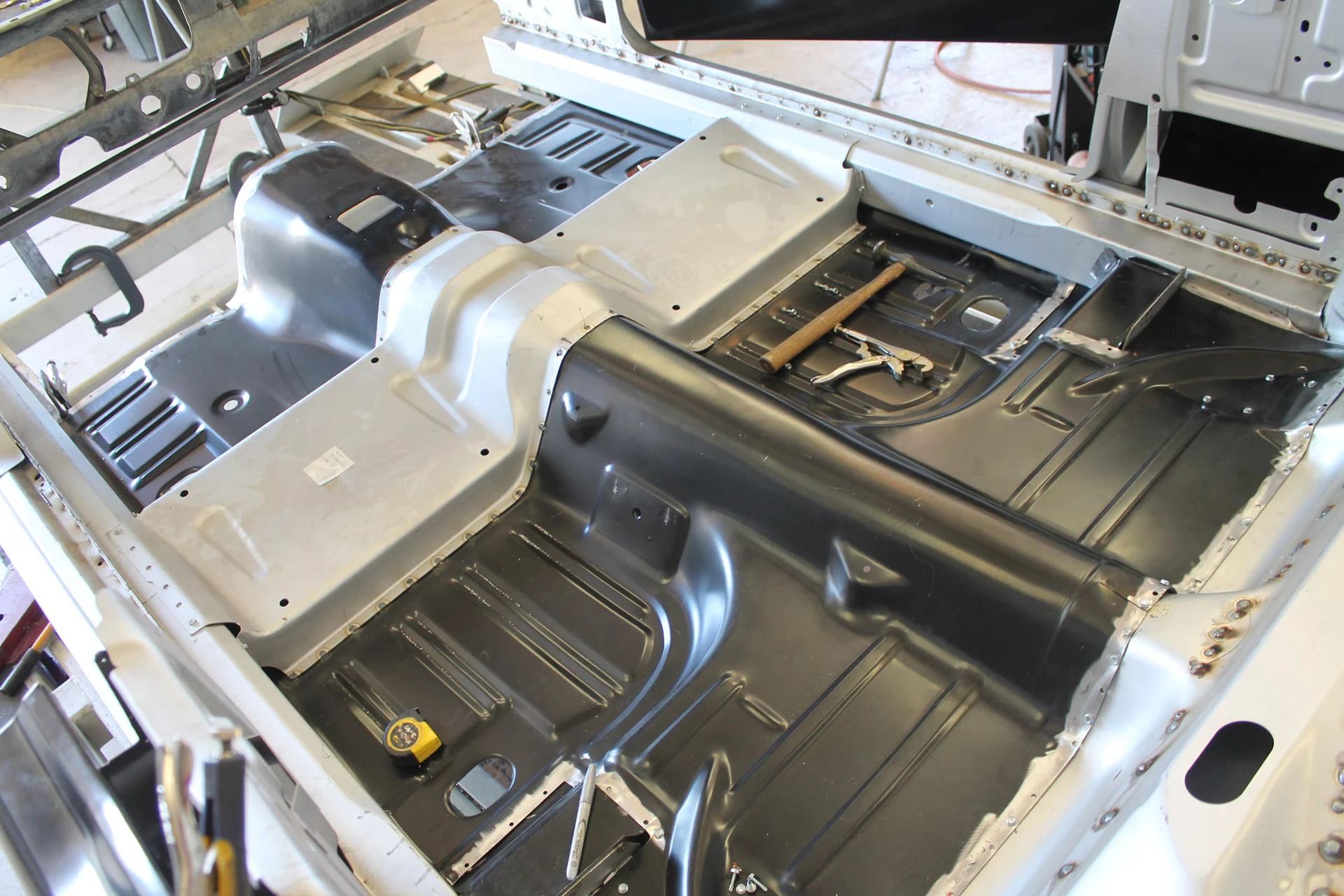 CC Tech: How the Mustang, Cougar, And Maverick Differed From The Original Ford Falcon Platform 10 New floorpan and crossmember being installed in a 1965 Ford Mustang convertible