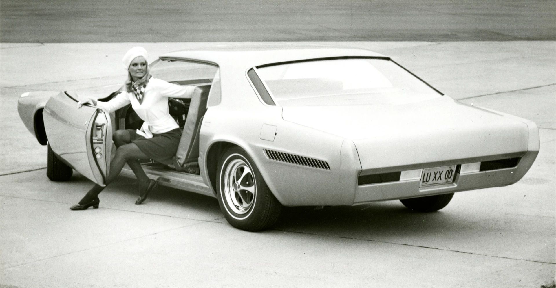 1968 Ford Techna Concept Car: Retro-Future Anachronism With A Weird Offset Driveshaft And Power Doors 4 B&W photo showing a female model getting out of the driver's side of the 1968 Ford Techna concept car
