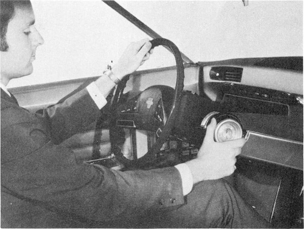 1968 Ford Techna Concept Car: Retro-Future Anachronism With A Weird Offset Driveshaft And Power Doors 11 B&W photo of a man in a suit demonstrating the steering column adjustment of the Ford Techna concept car