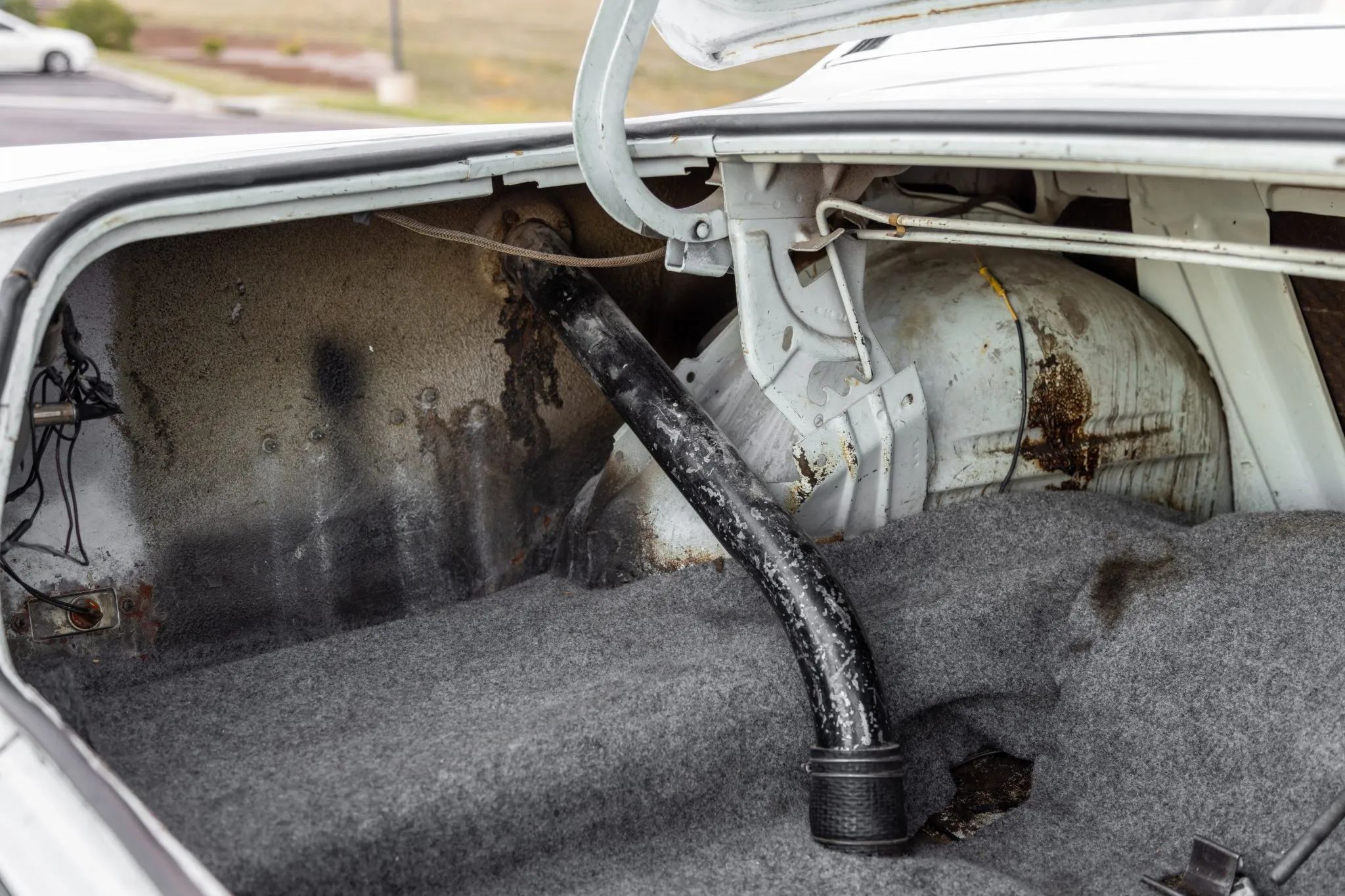 Fuel filler in the left side of the trunk of a white 1970 Ford Falcon coupe