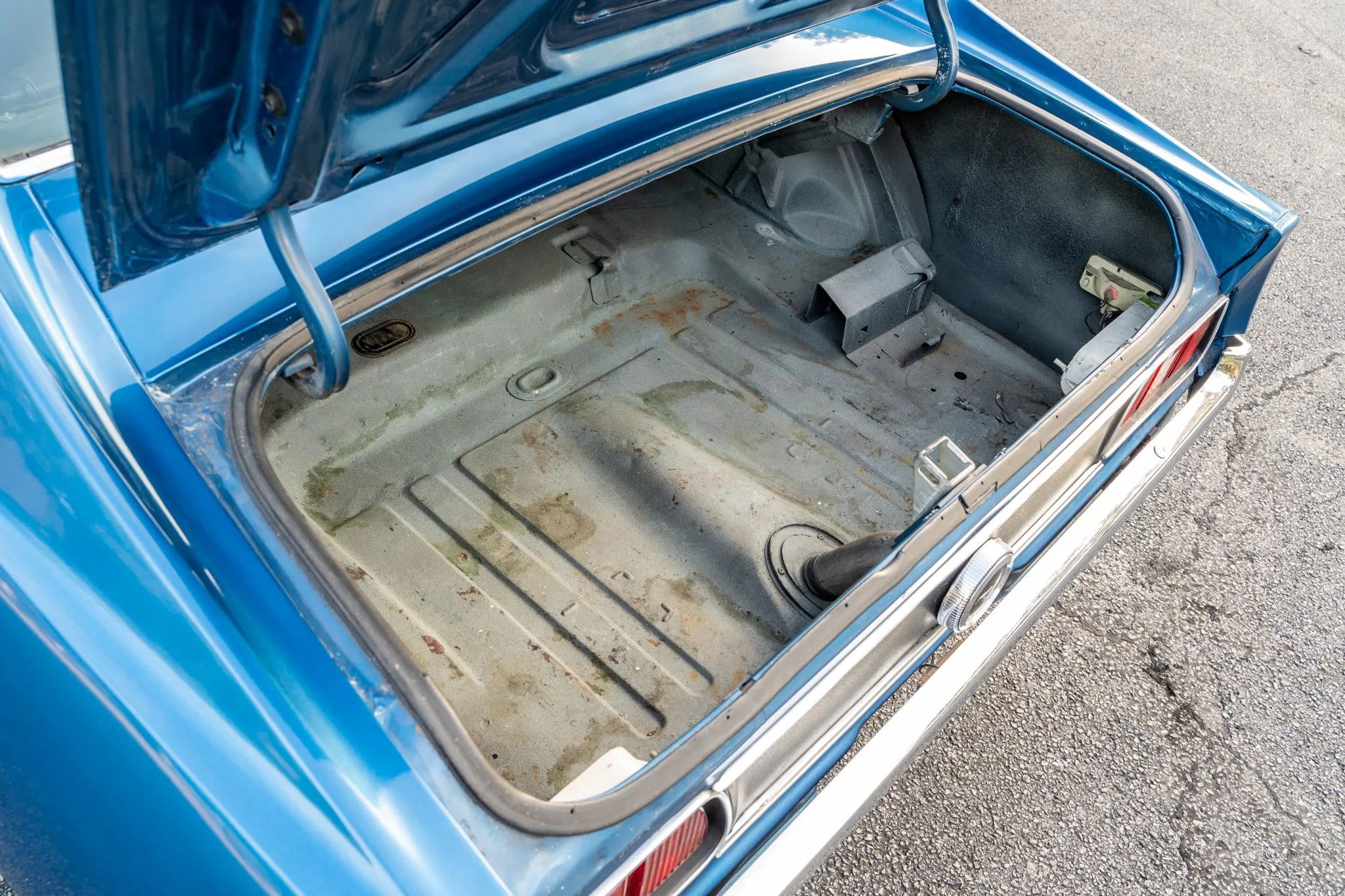 Trunk of a blue 1971 Ford Mustang hardtop with the trunk mat removed