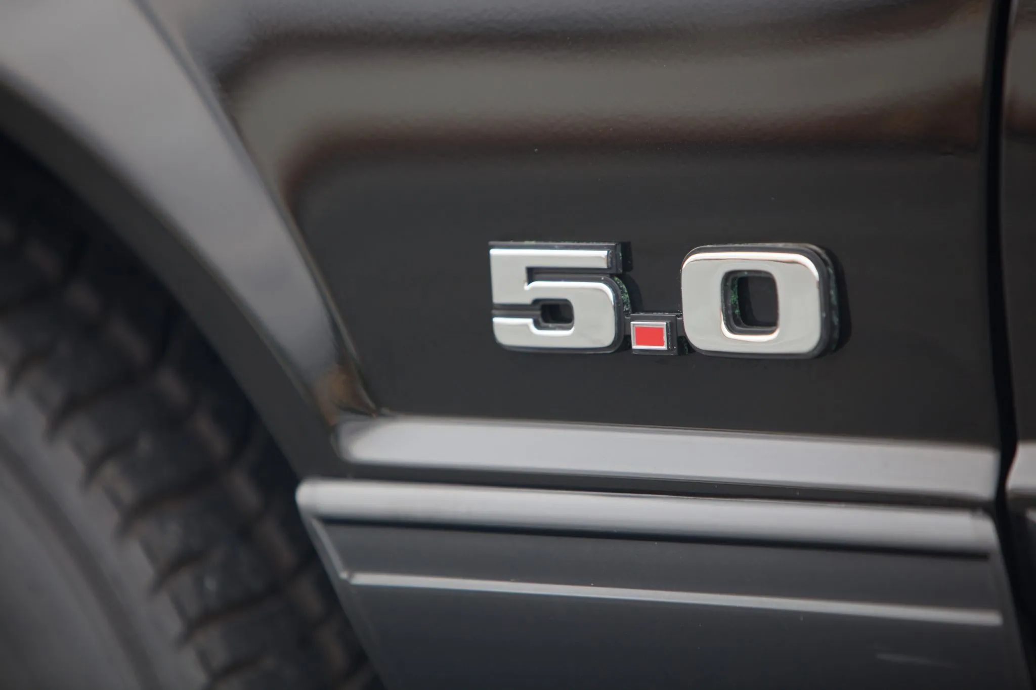 Rare 1995 Ford Mustang GTS Was A Short-Lived Reinvention Of The Old LX 5.0L 4 5.0 badge on the fender of a black 1990 Ford Mustang LX 5.0L