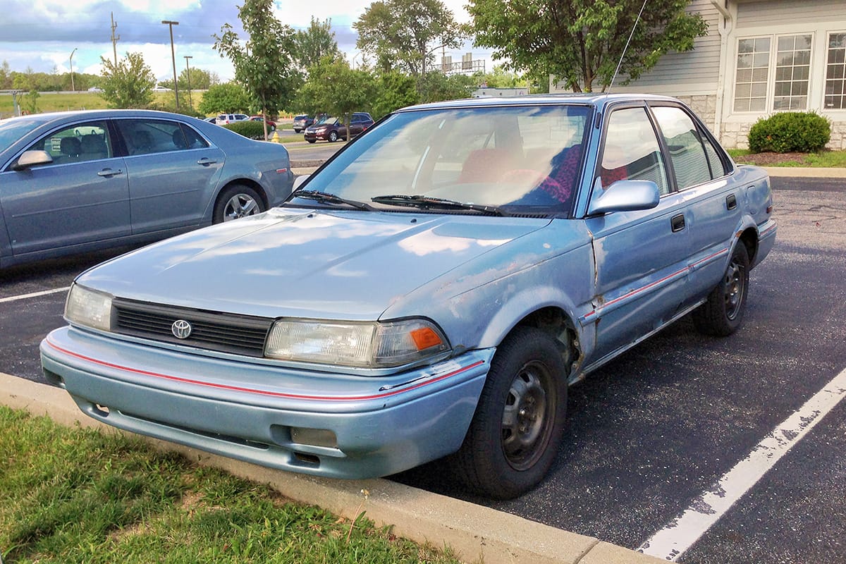 A 1988-1991 4-door Toyota Corolla in light blue. 