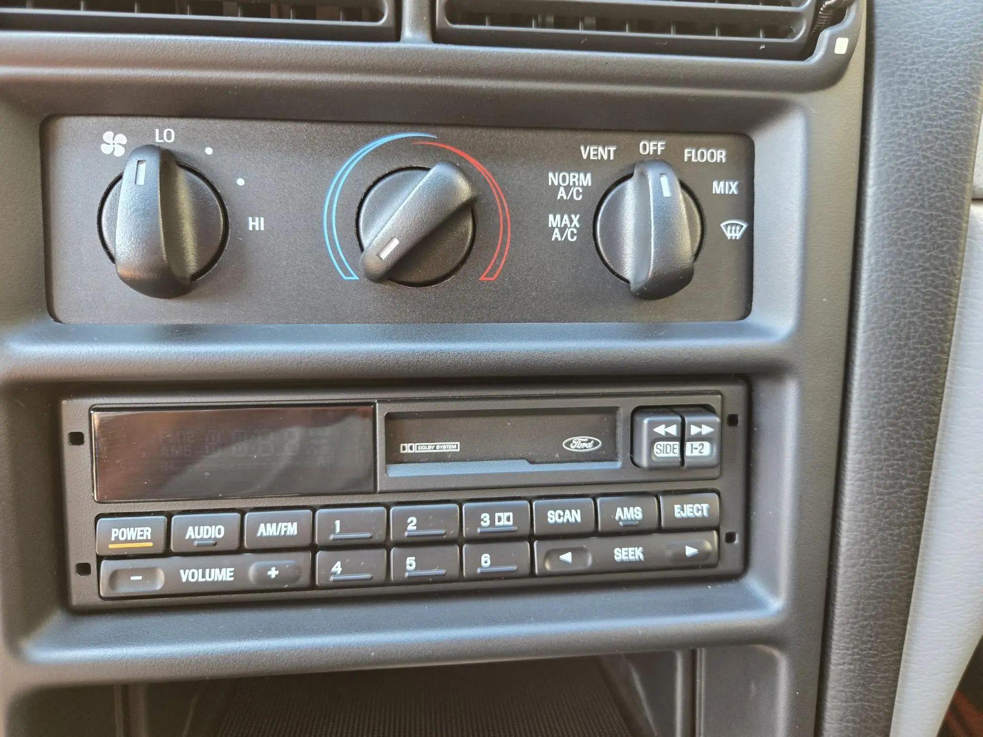 Rare 1995 Ford Mustang GTS Was A Short-Lived Reinvention Of The Old LX 5.0L 8 HVAC controls and AM/FM cassette player in a 1995 Ford Mustang GTS with gray interior