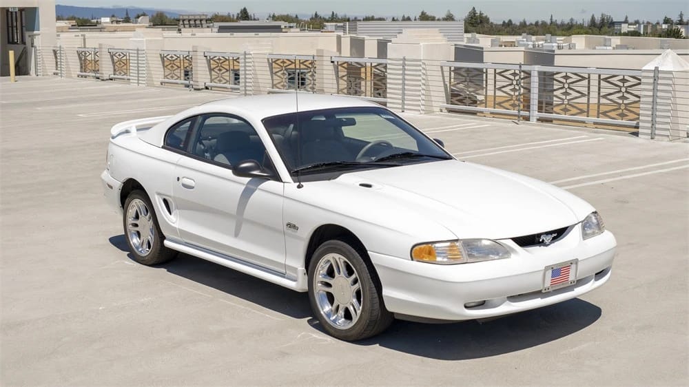 Rare 1995 Ford Mustang GTS Was A Short-Lived Reinvention Of The Old LX 5.0L 19 High-angle front 3q view of a white 1996 Ford Mustang GT coupe with foglamps, a rear spoiler, and 17-inch wheels