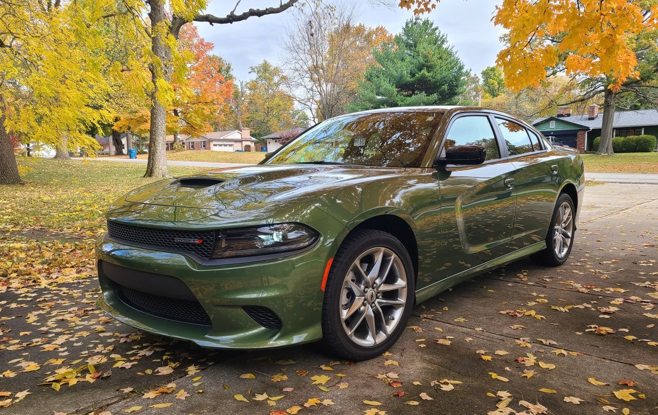 Photo of a green 2023 Dodge Charger parked under some fall trees