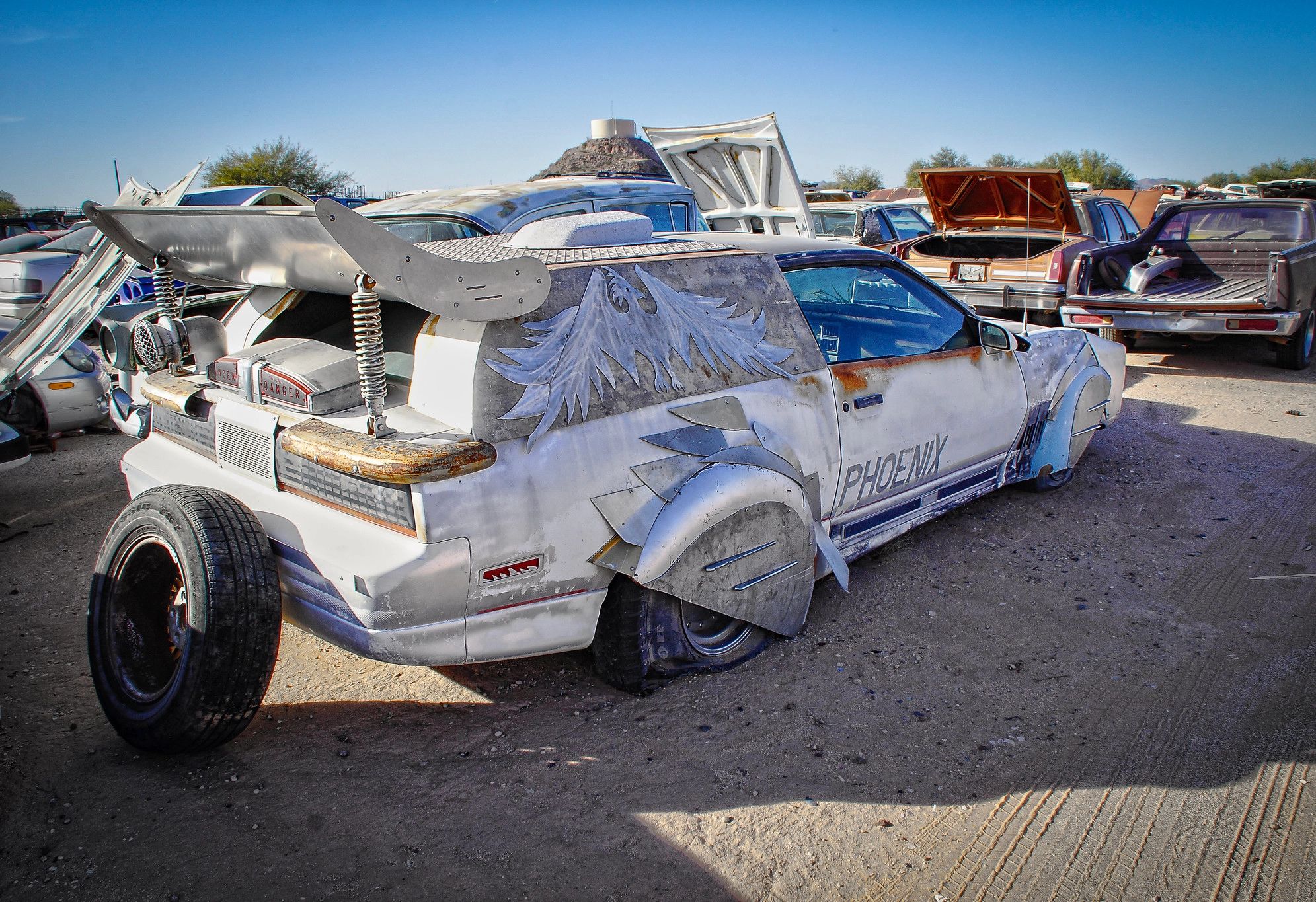 Curbside Find: From Firebird To Phoenix – Can You Identify The Pieces Of This Strange Art Car? 1 Photo of a heavily modified Pontiac Firebird with a painting of a phoenix on the rear window, the word "PHOENIX" on the passenger door," and a massive rear wing