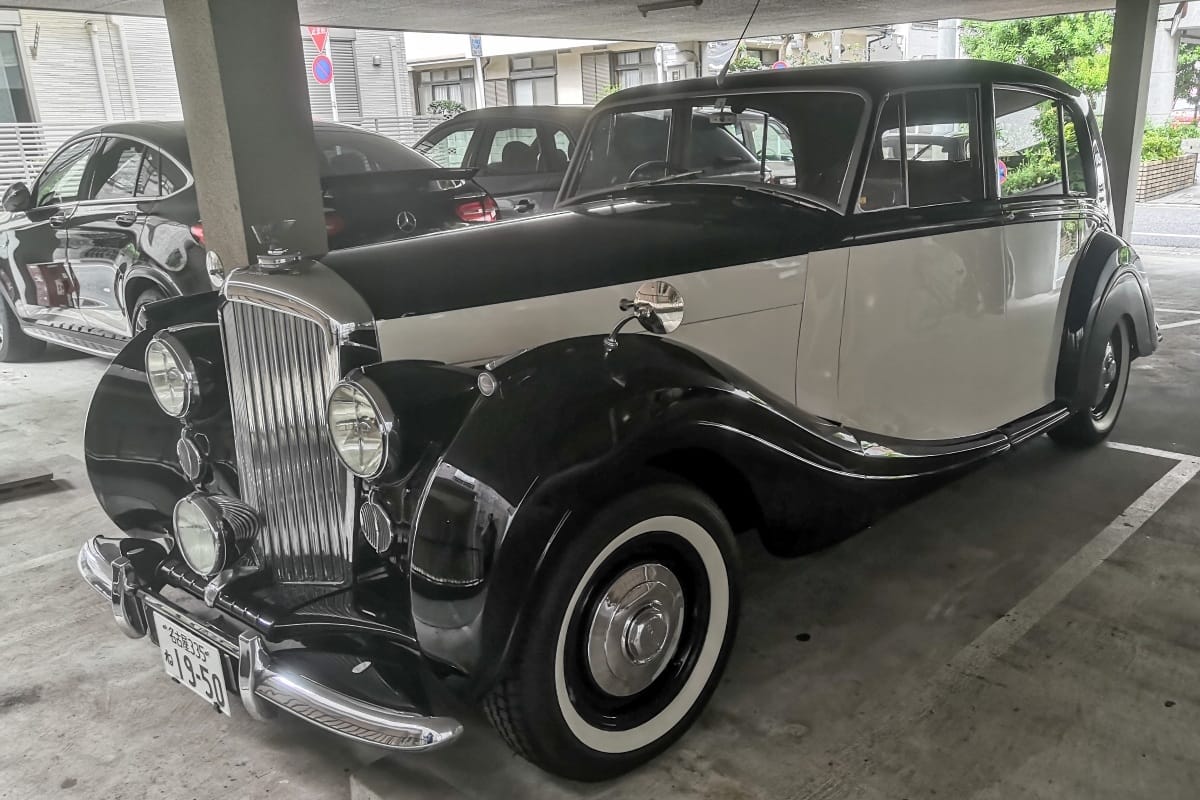 Photo of a two-tone black and white 1950 Bentley Mark IV sedan in a Japanese parking structure
