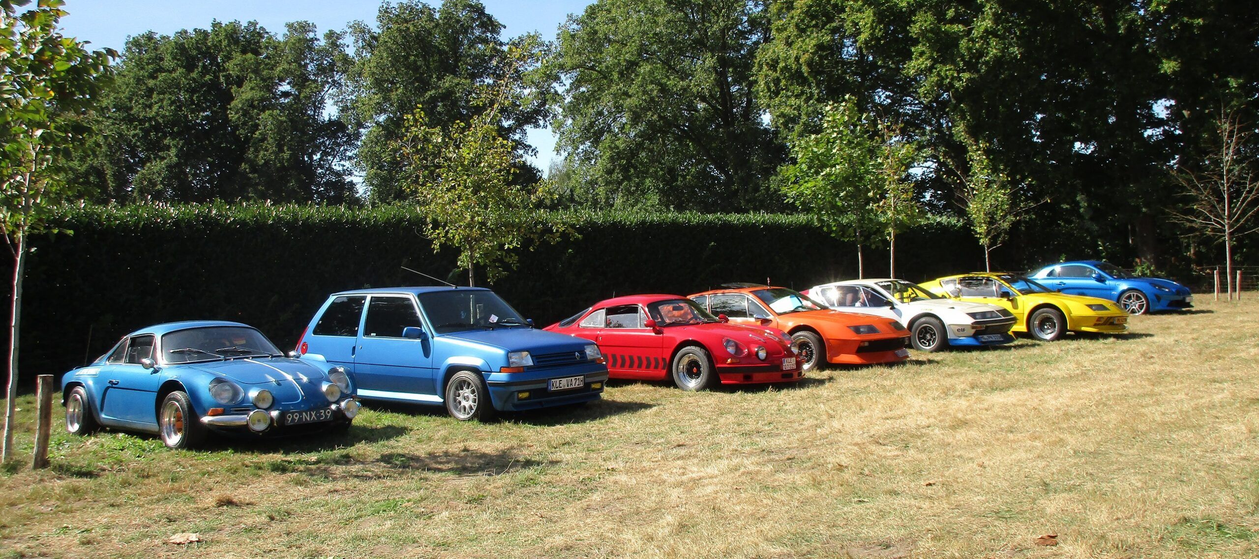 Photo of a blue Renault 5 GT Turbo in a line-up with a line-up of low-slung Renault-powered Alpine sports cars, all of which make the small R5 look really large and tall