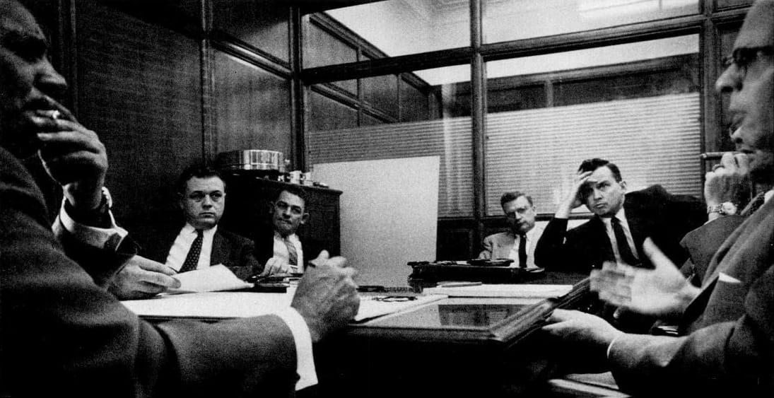 B&W photo of engineers in a meeting