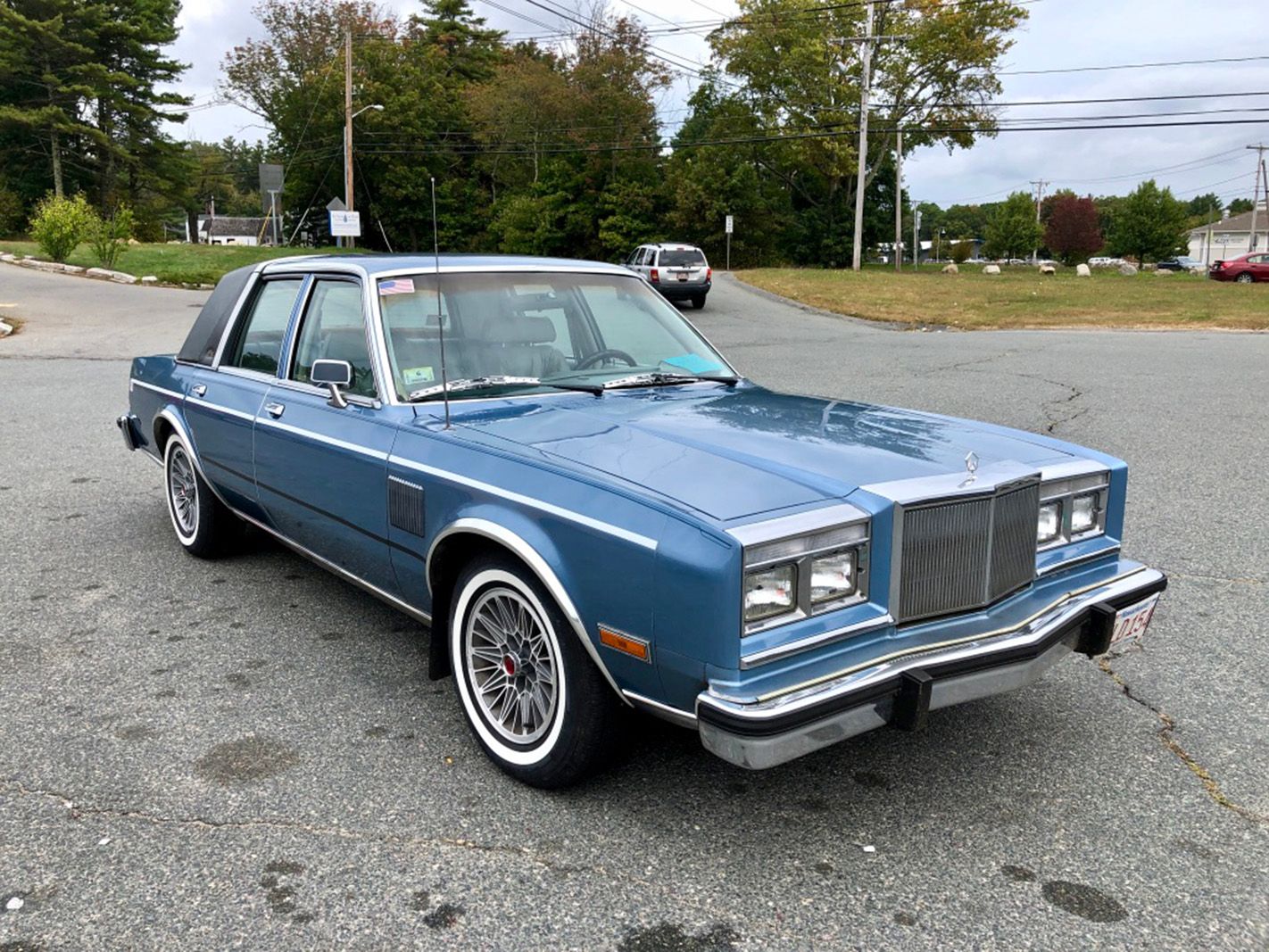Three quarter front view of a 1985 Chrysler Fifth Avenue in blue.