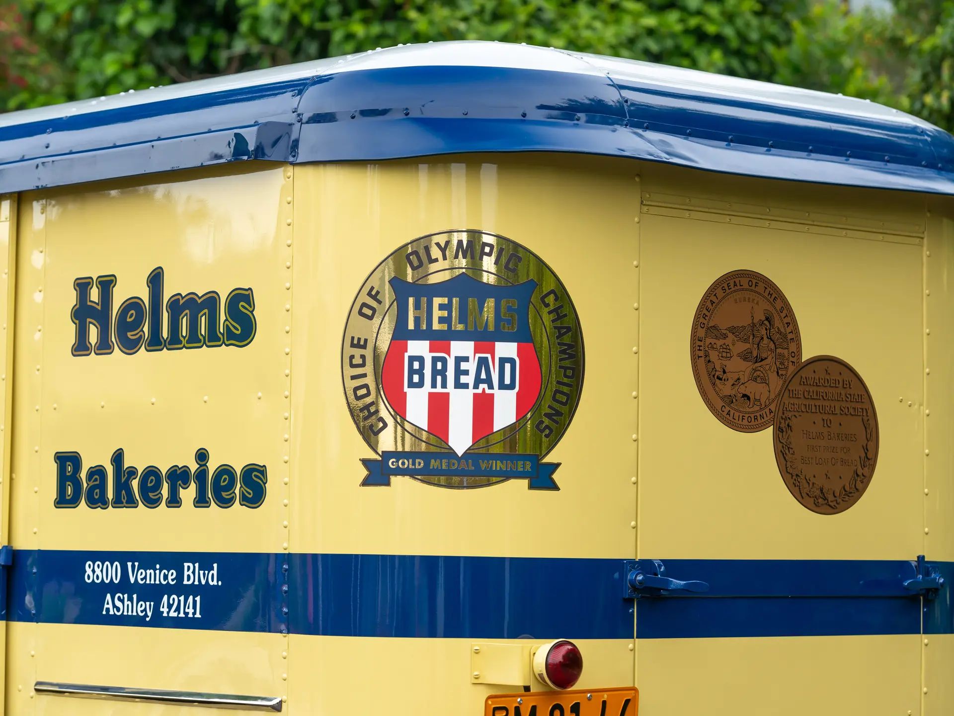 Helms Bakeries & The Twin Coach Delivery Unit: These Clever Compact Vans Used To Be "Daily At Your Door" 24 Signage on the 1936 Helms Coach, showing the Helms Bakeries name and a logo reading "HELMS BREAD: Choice of Olympic Champions: Gold Medal Winner"