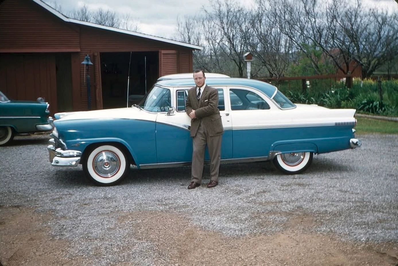 Classic Fords In Their Prime: Vintage Photos From The 1950s 1 Old photo of a man in a suit leaning against the door of a two-tone blue-and-white 1956 Ford