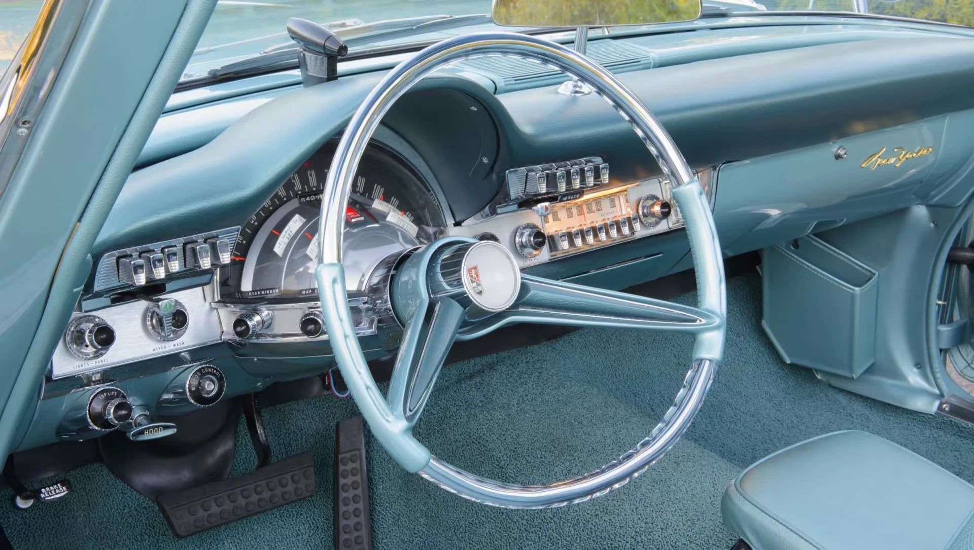 Dashboard and transparent oval wheel of a 1960 Chrysler Imperial convertible with a blue interior