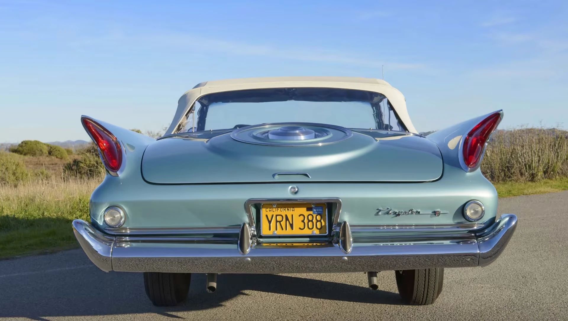 Rear view of a blue 1960 Chrysler New Yorker convertible with its top up
