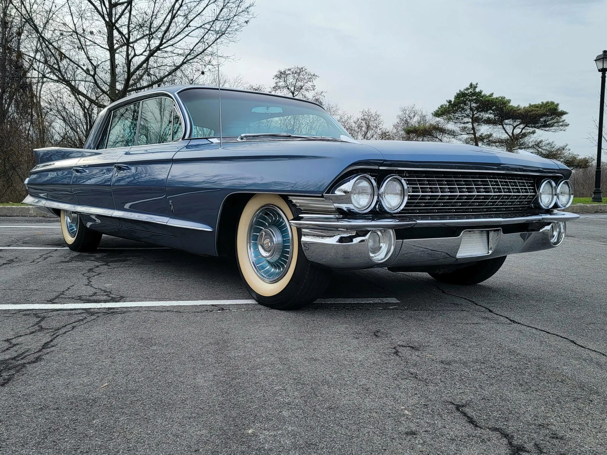 Low-angle front 3q view of a blue 1961 Cadillac four-door hardtop