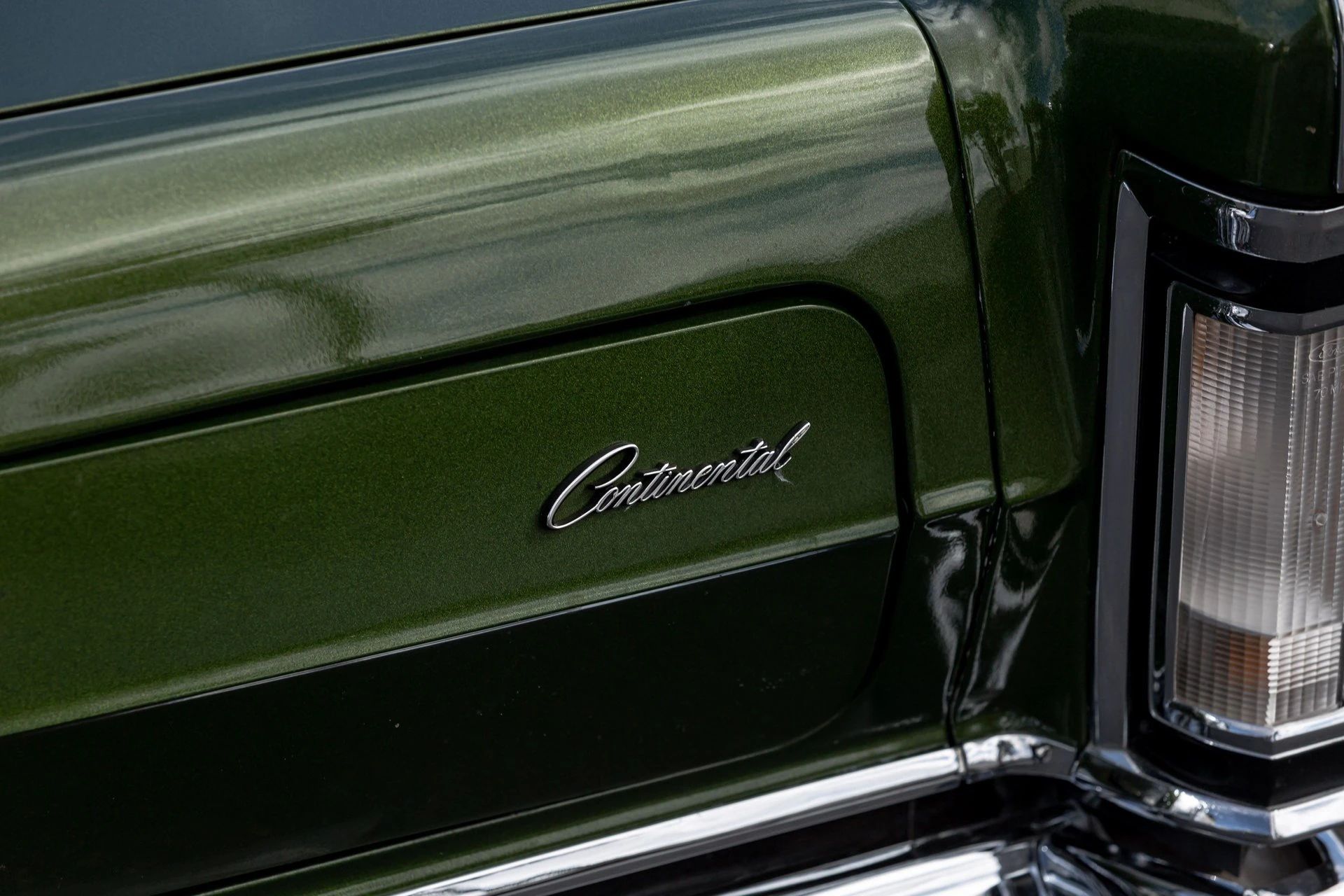 Headlamp cover and "Continental" insignia on a metallic green 1971 Mark III