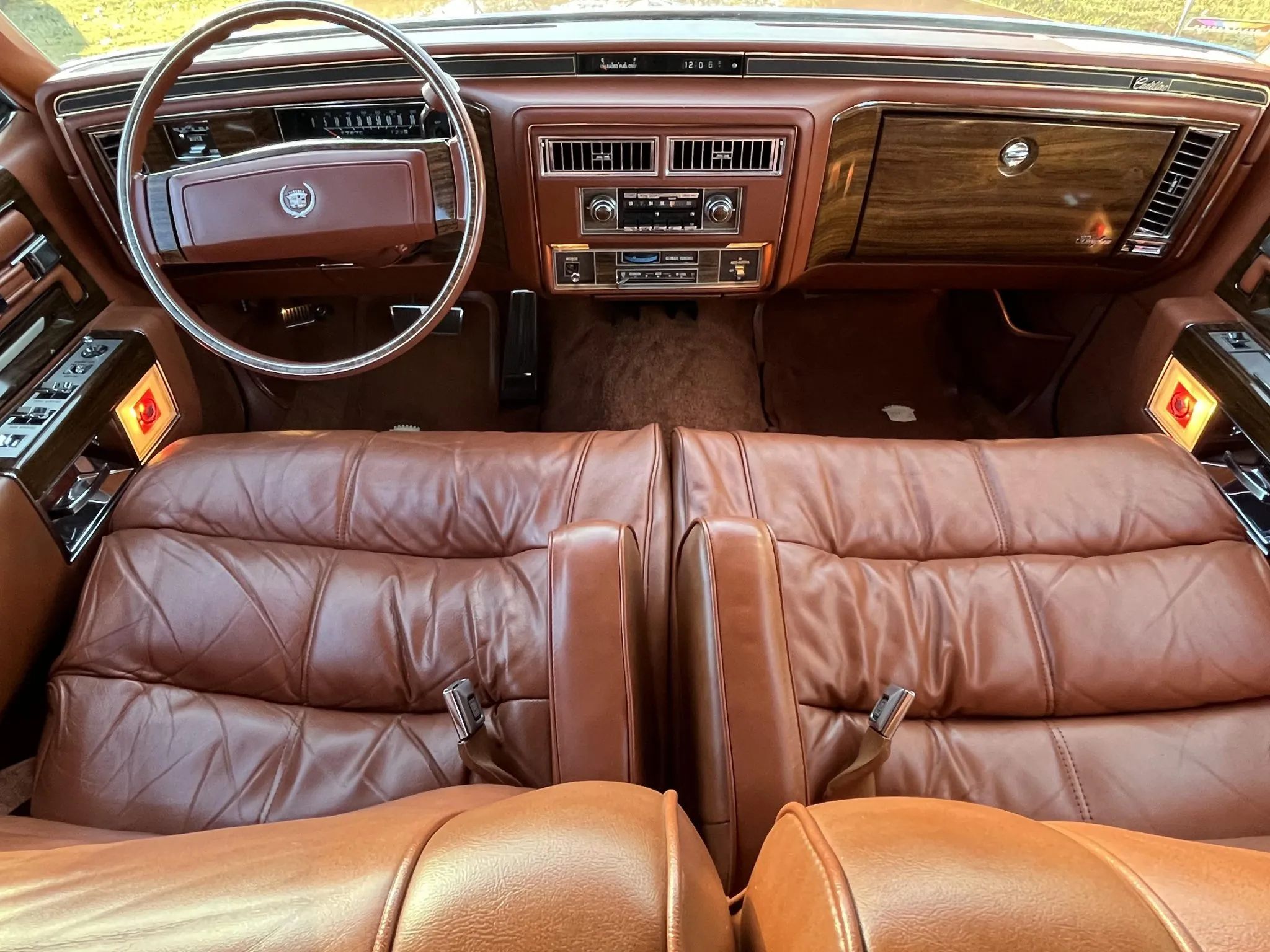 Split front seats of a 1977 Cadillac Fleetwood Brougham with orange leather upholstery