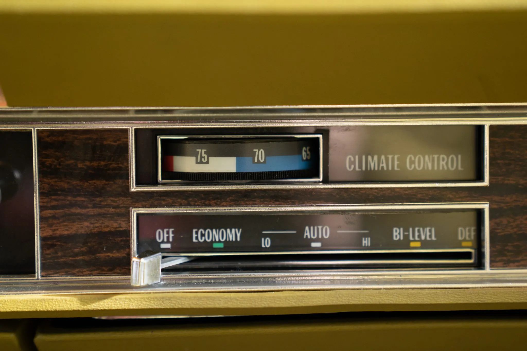 Automatic climate control panel in a 1977 Cadillac with a gold dashboard