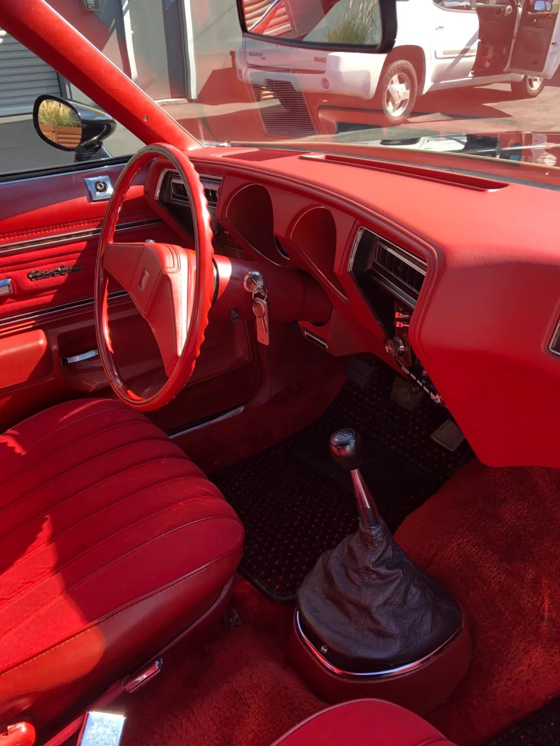 Dashboard and shifter of a 1977 Cutlass Supreme with red interior