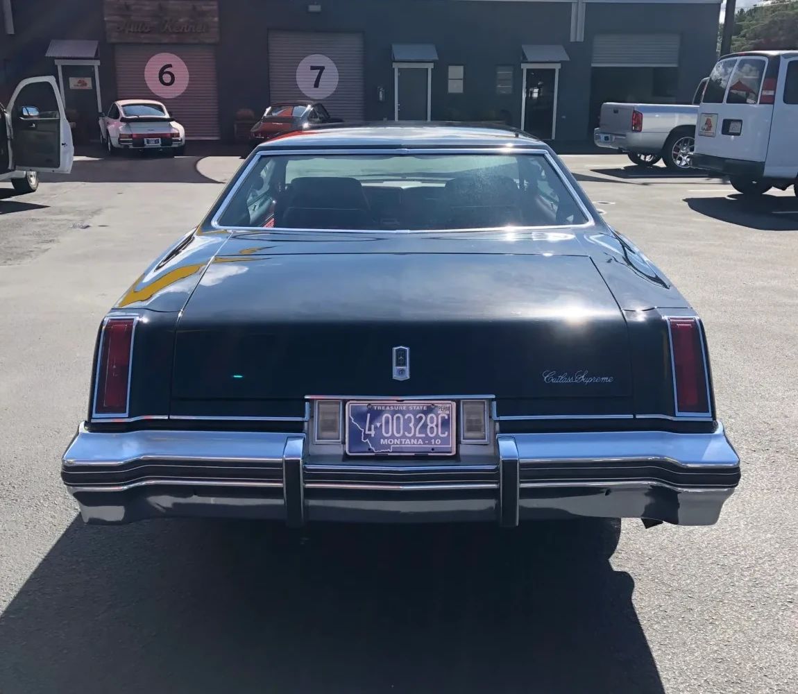 Rear view of a black 1977 Oldsmobile Cutlass Supreme