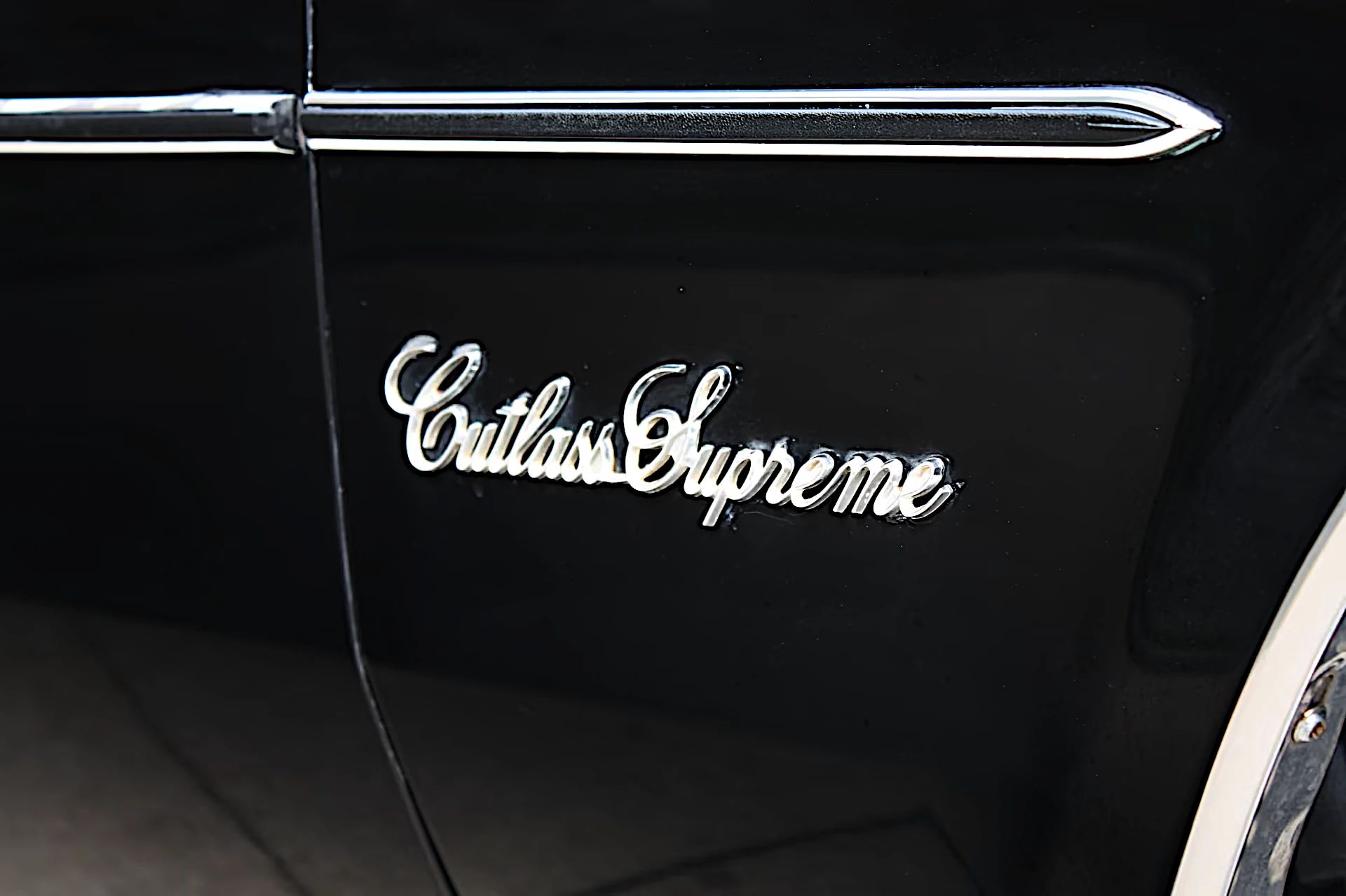 Cutlass Supreme badge on a black car 