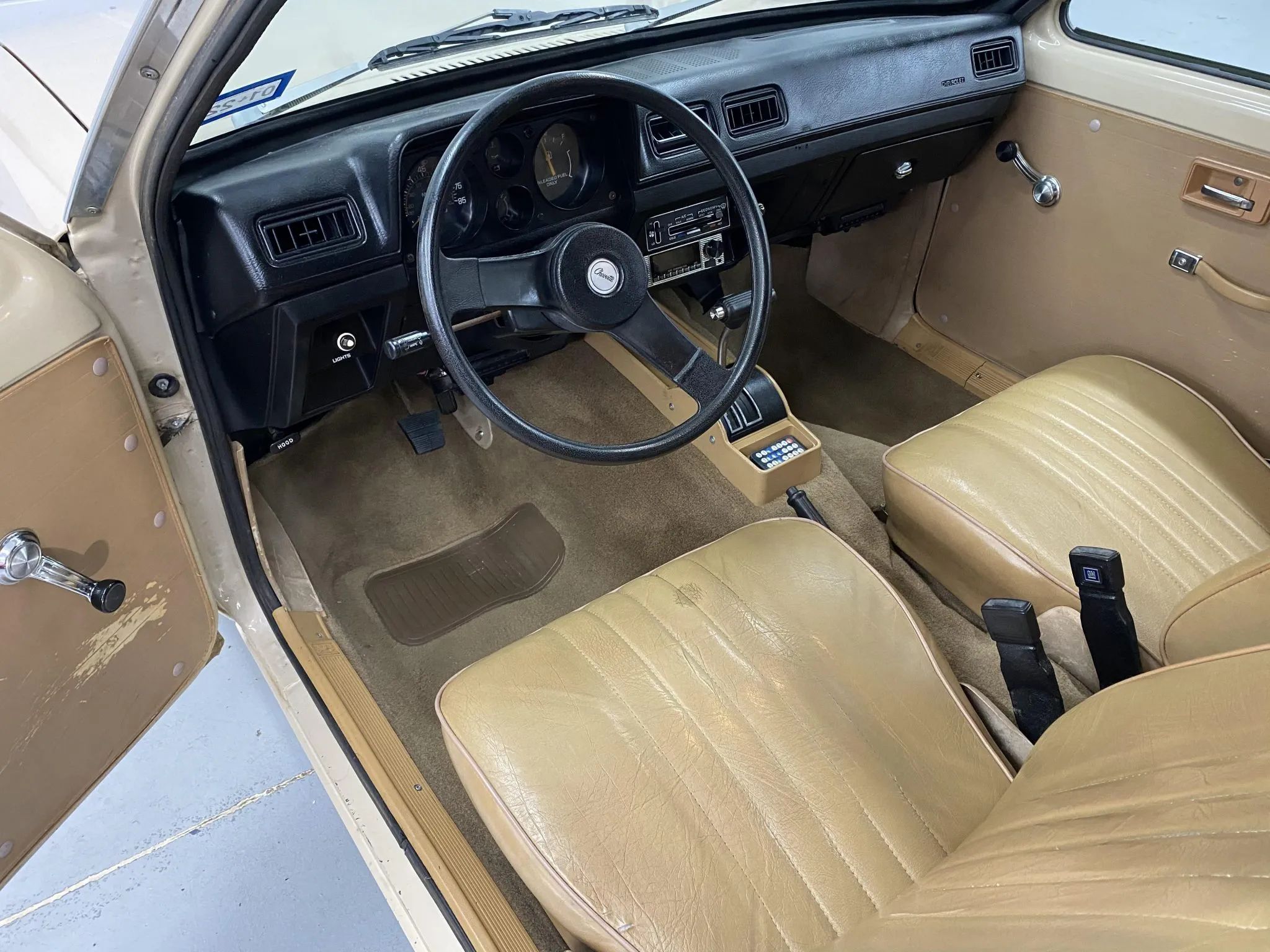 Dashboard and front seats of a 1981 Chevrolet Chevette Scooter with beige upholstery
