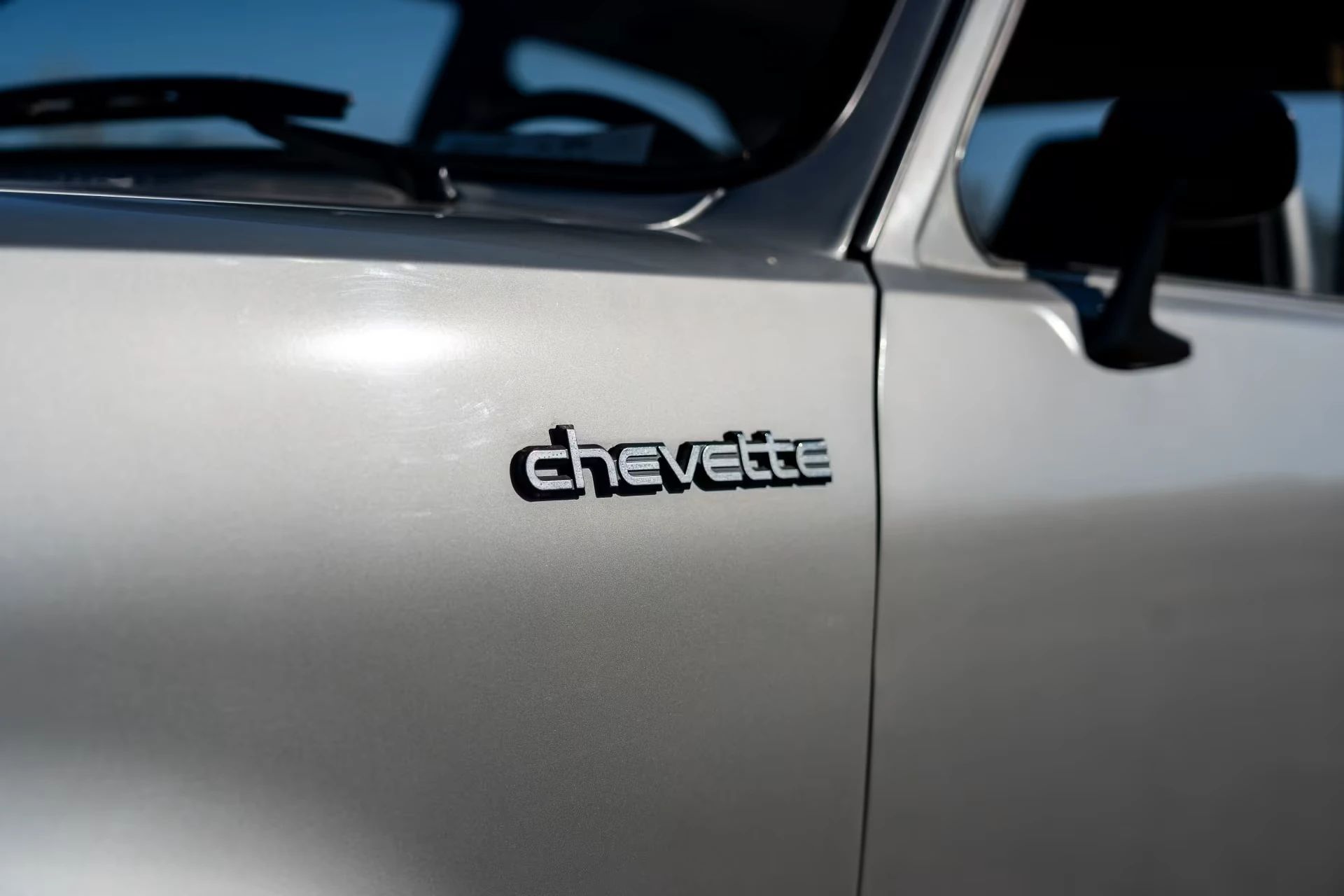 Chevette badge on the fender of a silver 1987 Chevrolet Chevette