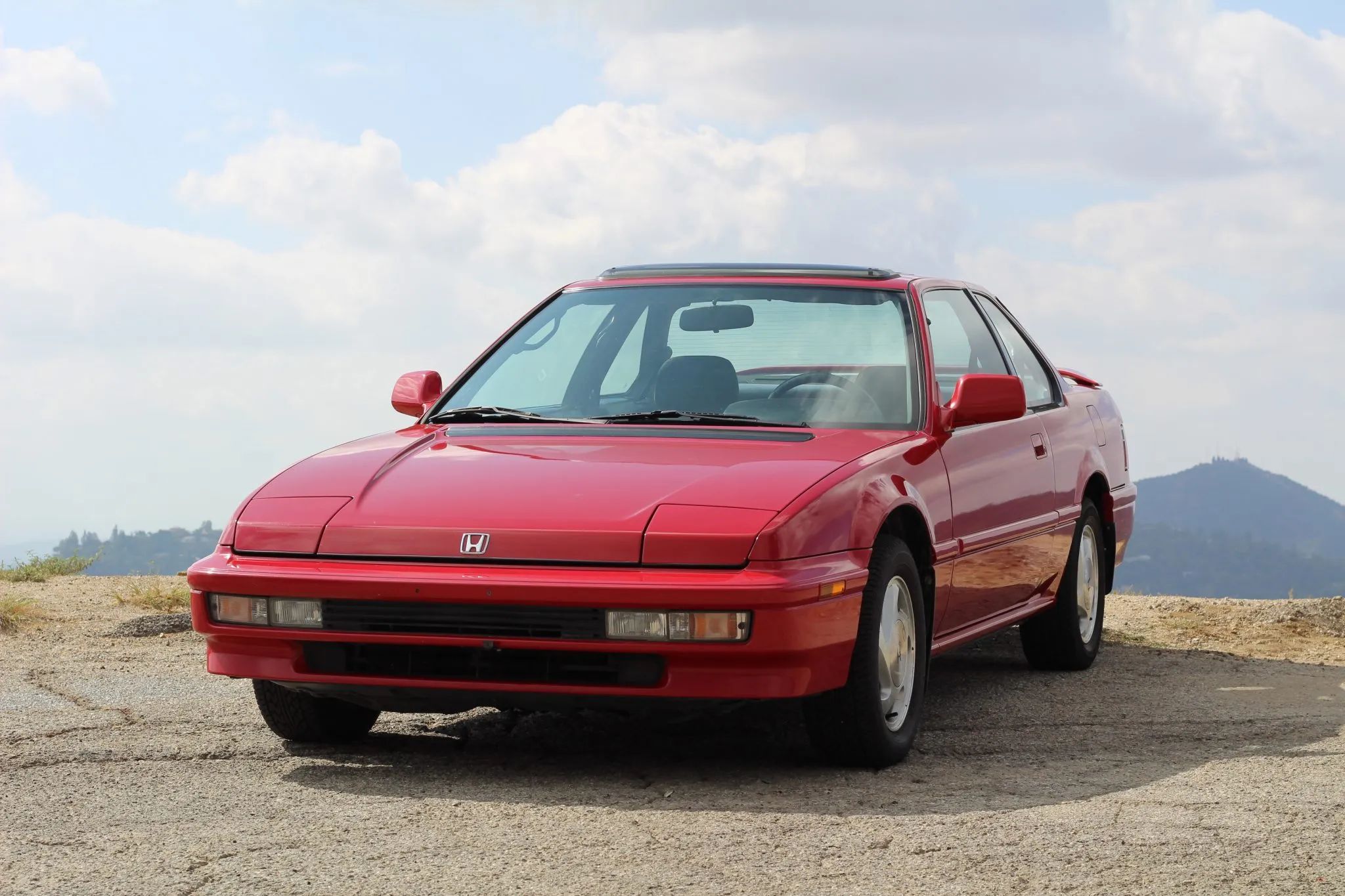 Front view of a red 1991 Honda Prelude on a mountainside