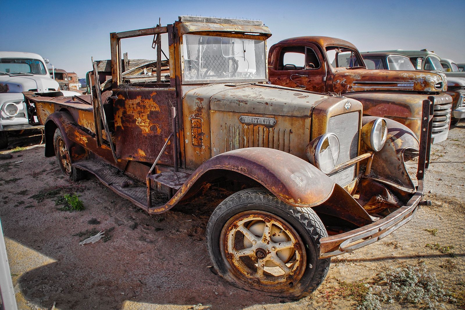 Photo of a rusty old International pickup truck in a junkyard