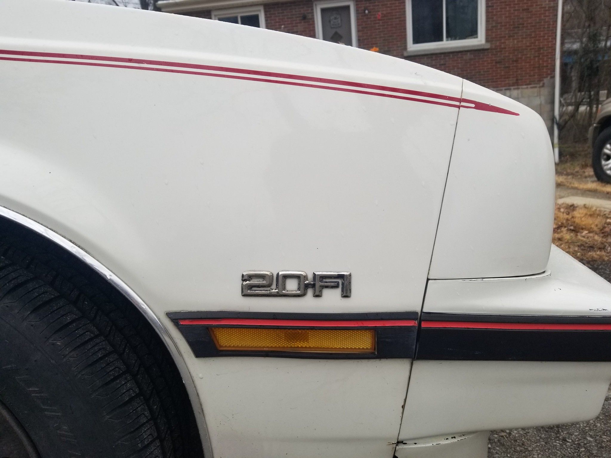 1986 Chevrolet Cavalier CS Hatchback: "America's Favorite Car" 2 Picture of 2.0-FI emblem on the fender of a 1986 Chevy Cavalier in white