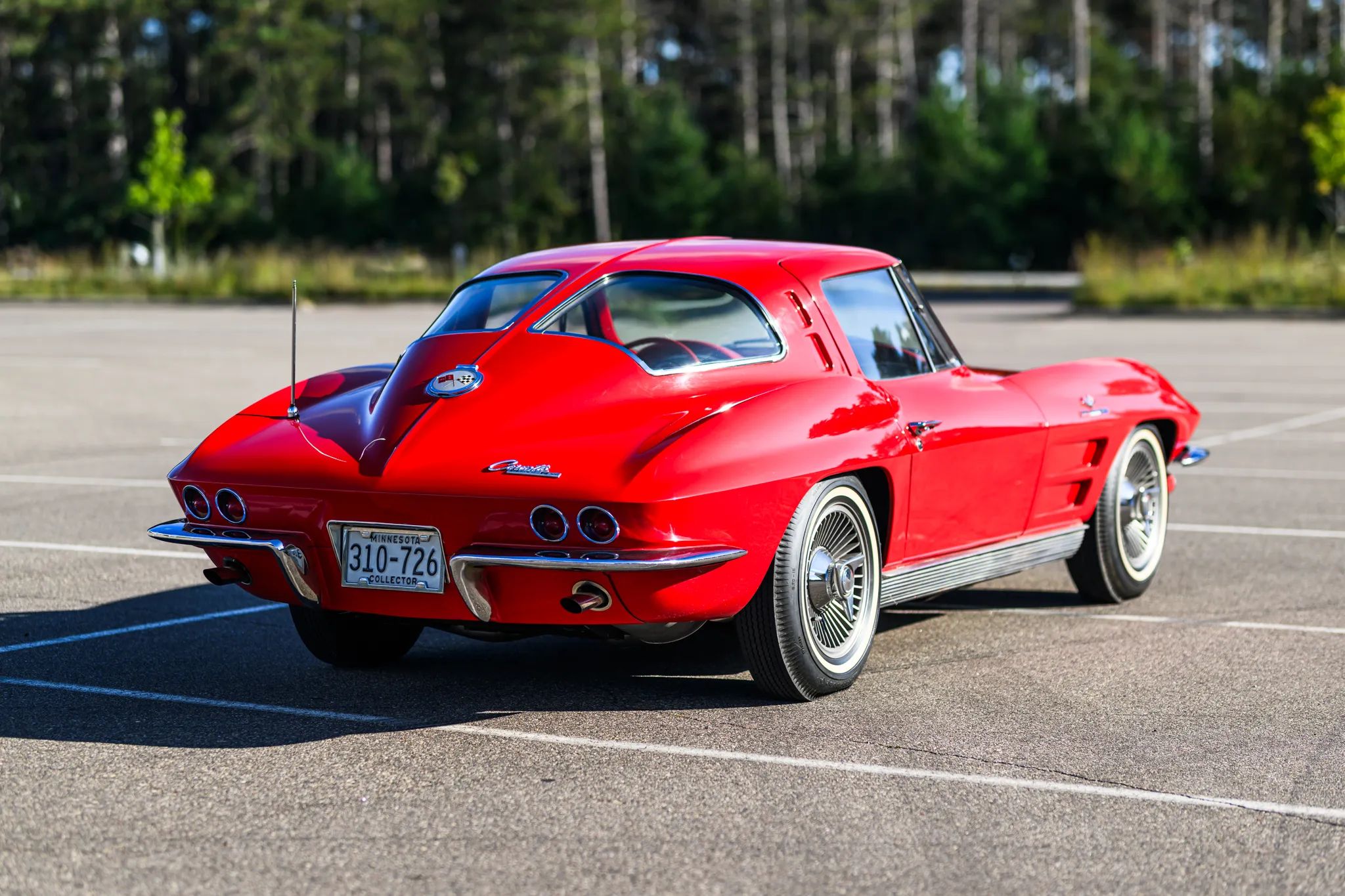 The Beach Boys' "Shut Down": A Fuel-Injected Sting Ray Might Be Closer To That Super Stock Dodge Than You'd Expect 14 Picture of the rear of a bright red 1963 Corvette Sting Ray in a parking lot setting