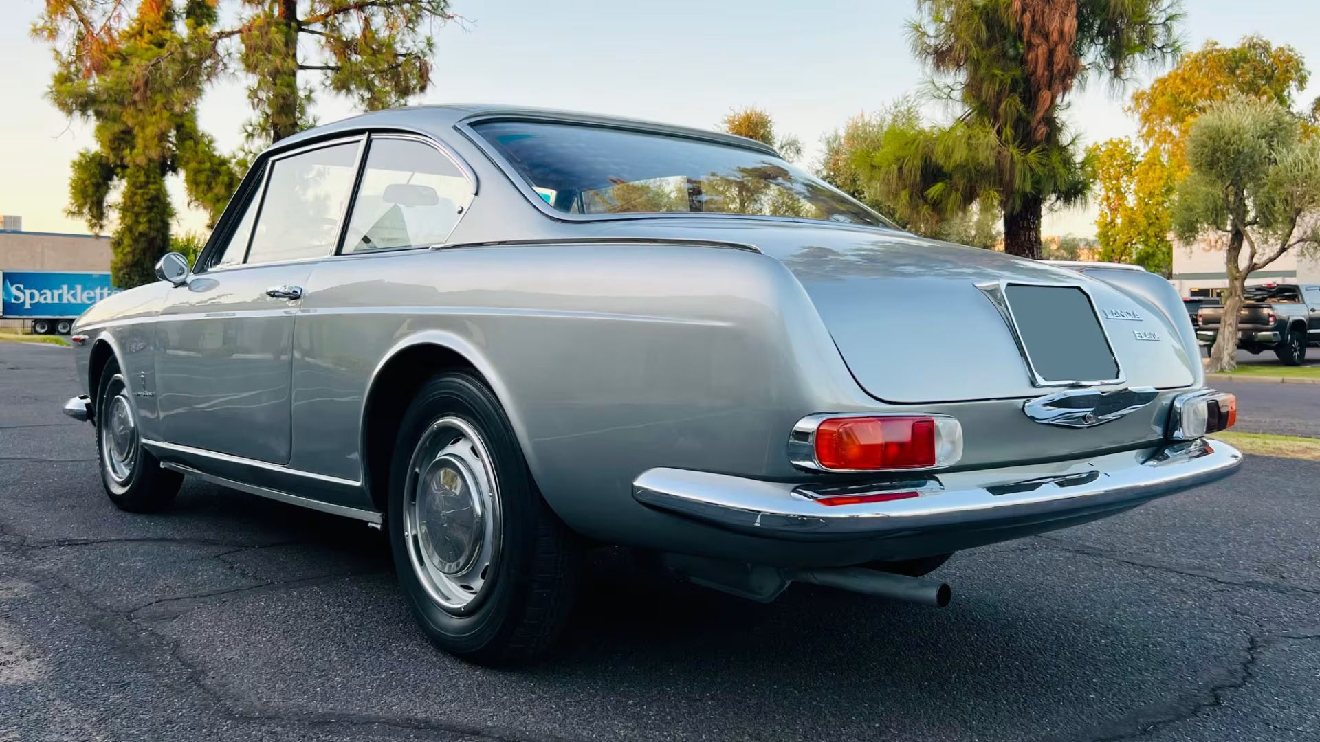 Pininfarina's Shared Language of Beauty in 1963—From Ferrari to FIAT 13 Picture of silver Lancia Flavia Coupe in a parking lot near sunset