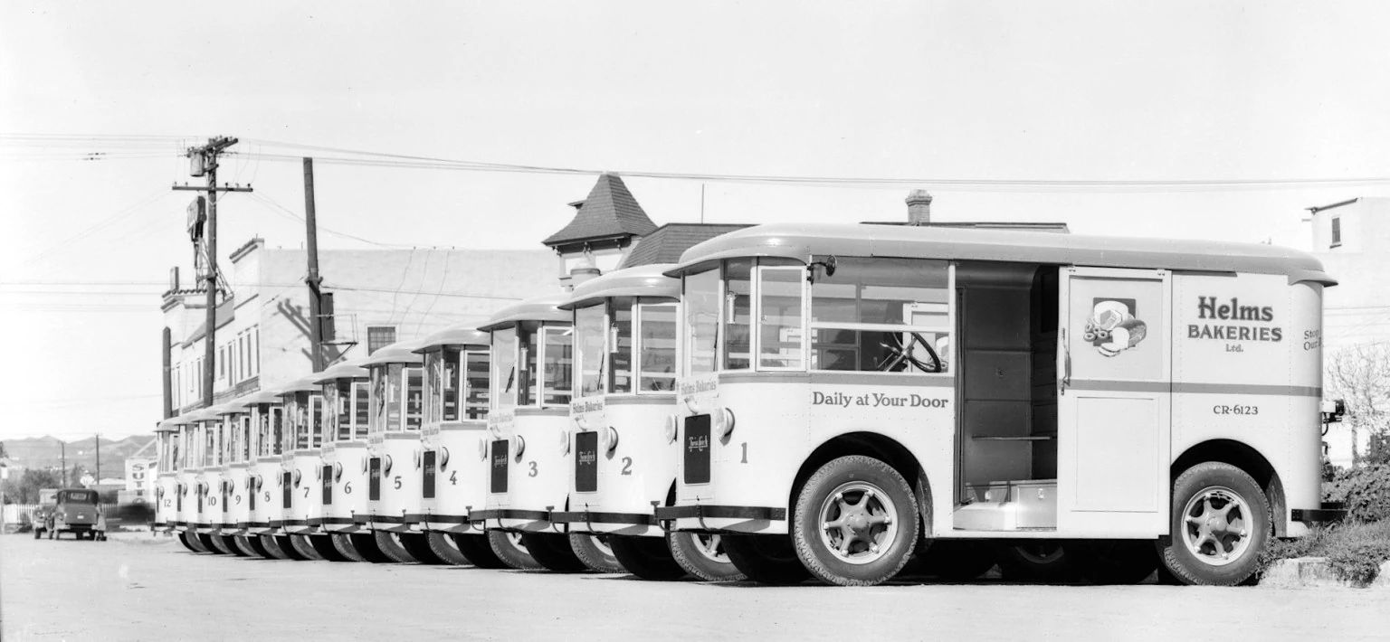 Helms Bakeries & The Twin Coach Delivery Unit: These Clever Compact Vans Used To Be "Daily At Your Door" 17 B&W photo showing a line of Helms Coaches
