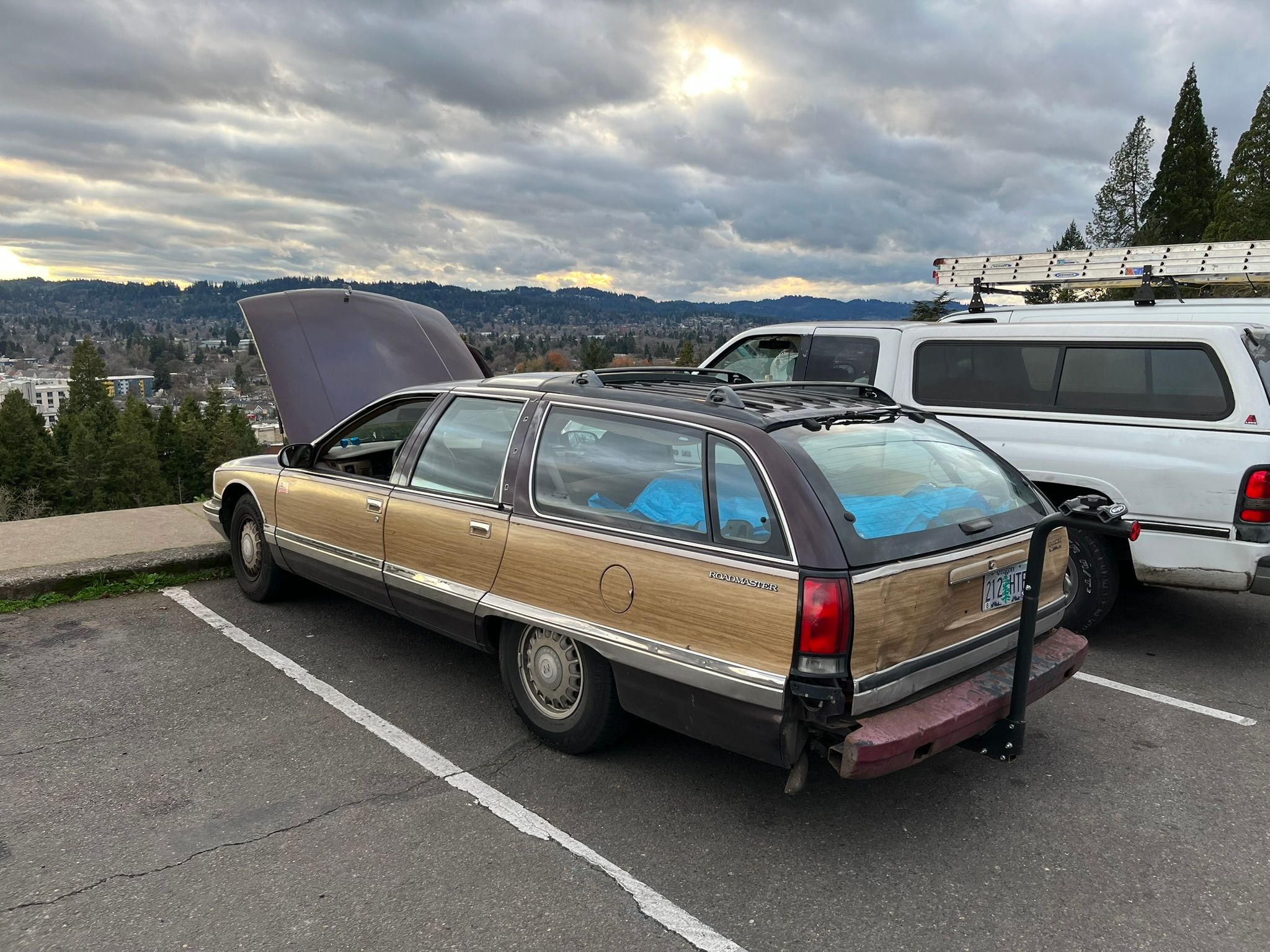 Photo of a brown 1995 Buick Roadmaster station wagon with its hood up in a parking lot