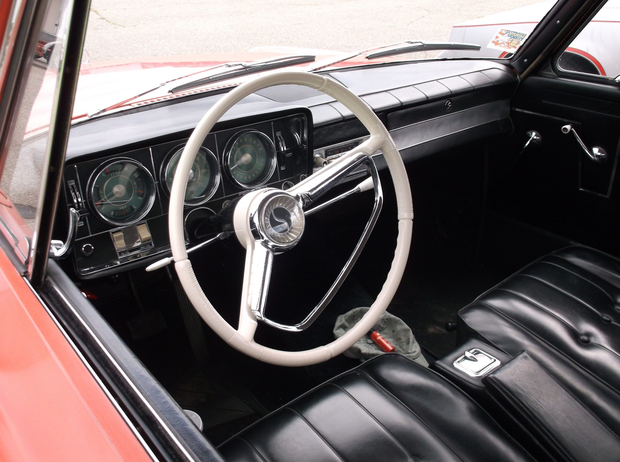 Image of 1965 Studebaker Daytona interior with black seats and white steering wheel