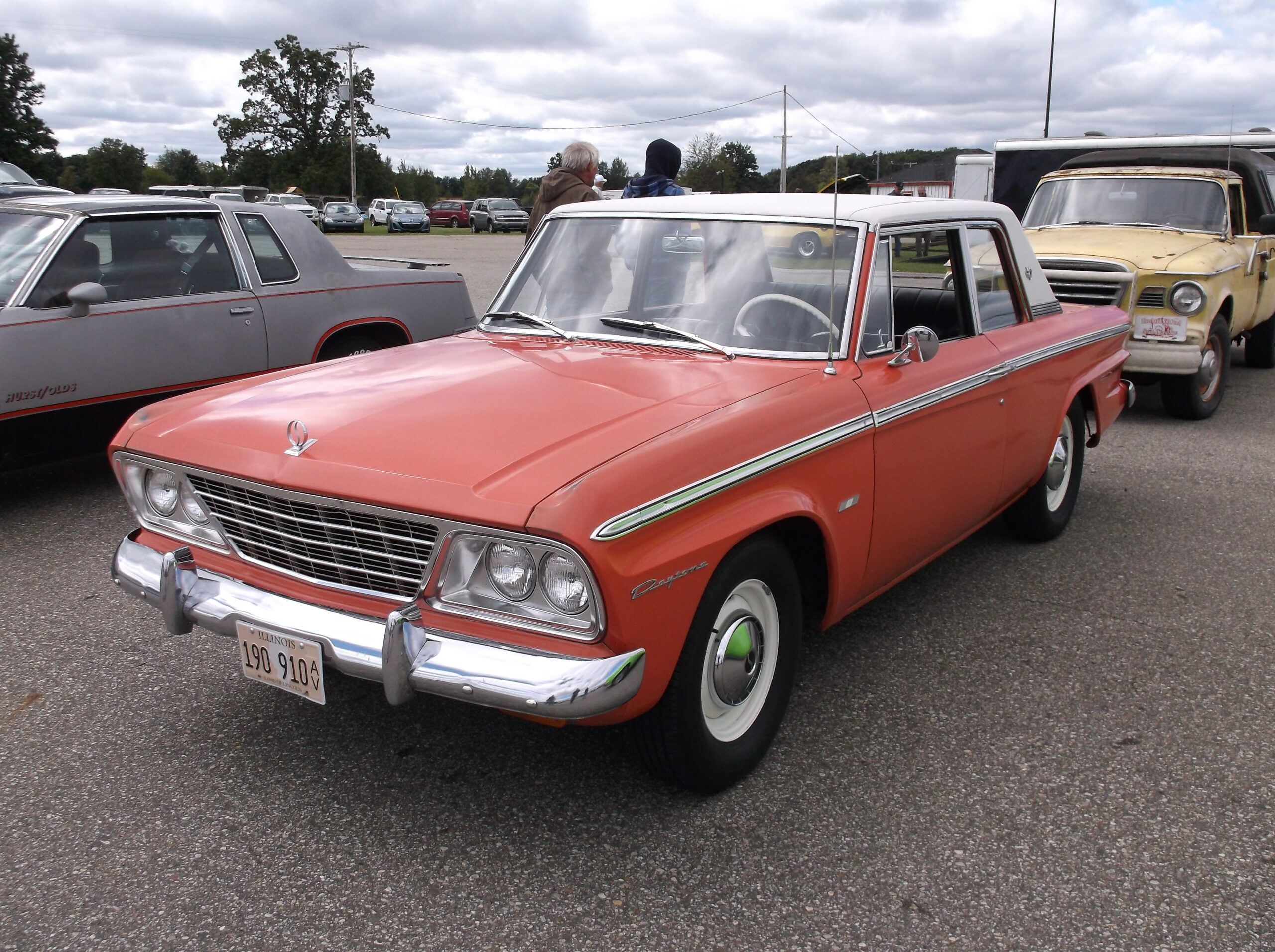 Image of faded red 1965 Studebaker Daytona in parking lot